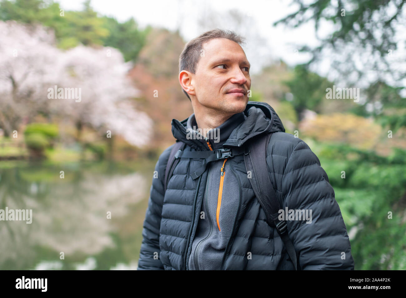 Tokyo, Japon sakura cherry blossom rose arbres fleurs d'arrière-plan flou au printemps Le printemps à Shinjuku gyoen touristiques avec l'homme par l'étang Lake Banque D'Images