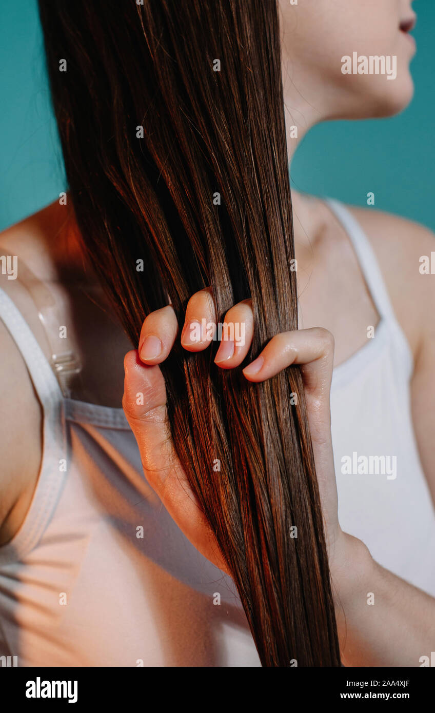 Femme d'appliquer de l'huile pour les cheveux Banque D'Images