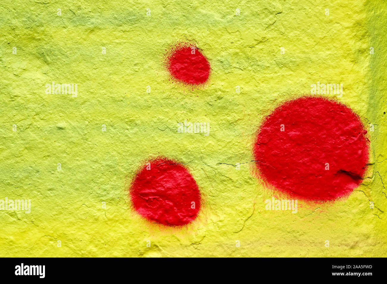 Tache de peinture rouge sur un fond jaune. Résumé fond de mur de pierre peinte. Les cercles rouges sur fond jaune. Banque D'Images