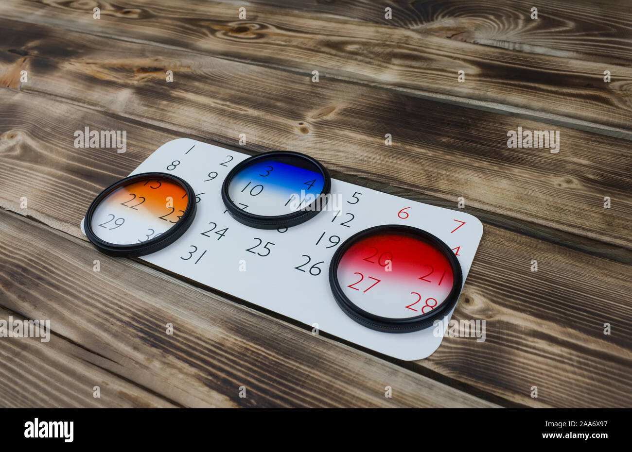 Feuille de calendrier et l'objectif de l'appareil en bois sur filtre Banque D'Images