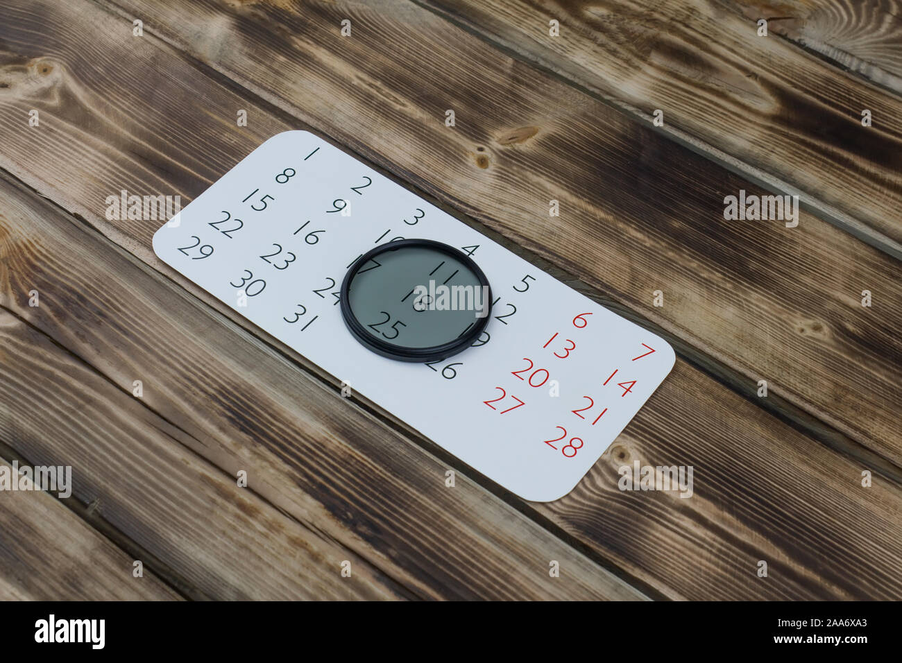 Feuille de calendrier et l'objectif de l'appareil en bois sur filtre Banque D'Images