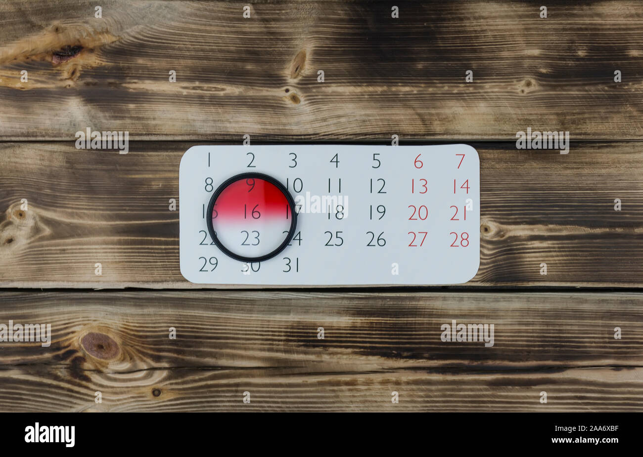 Feuille de calendrier et l'objectif de l'appareil en bois sur filtre Banque D'Images