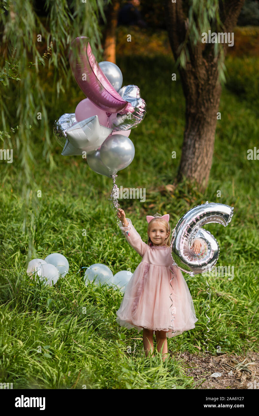 Tourne A L Exterieur De La Jolie Petite Fille Joyeuse Avec Des Cheveux Blonds Celebrer 6 Ans Anniversaire Avec Des Ballons Porter Des Vetements De Mode Ont Excite Photo Stock Alamy
