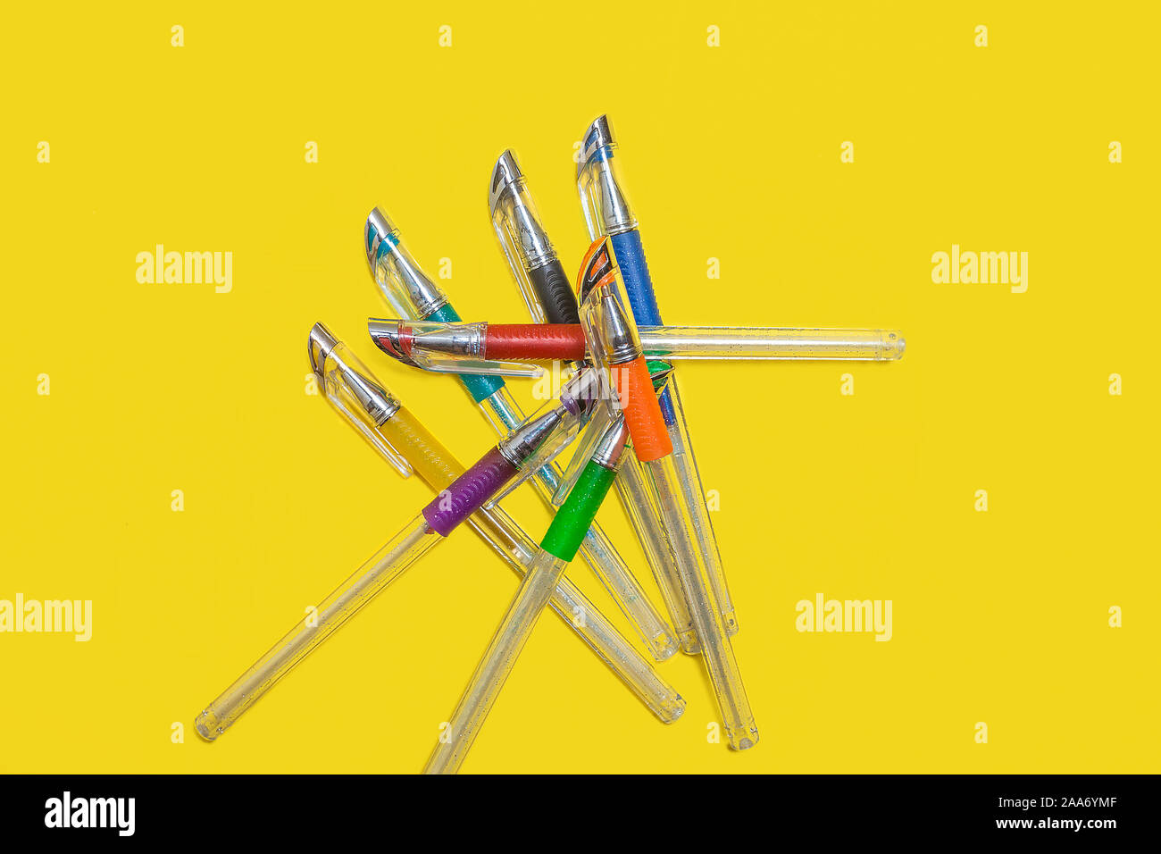 Tas de plumes de couleur sur un fond jaune Banque D'Images