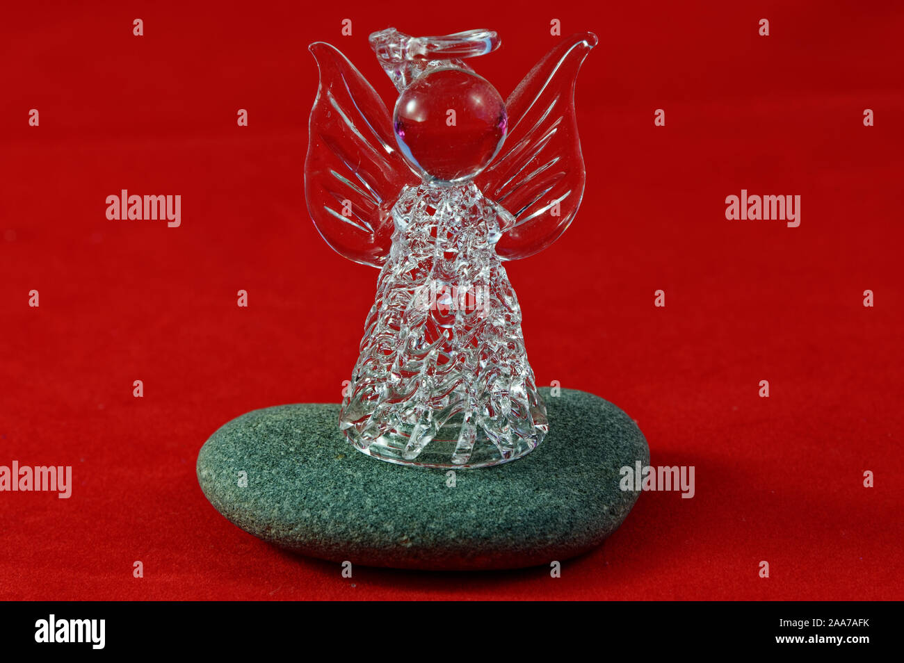 Un ange en verre est debout sur une pierre de rivière Banque D'Images