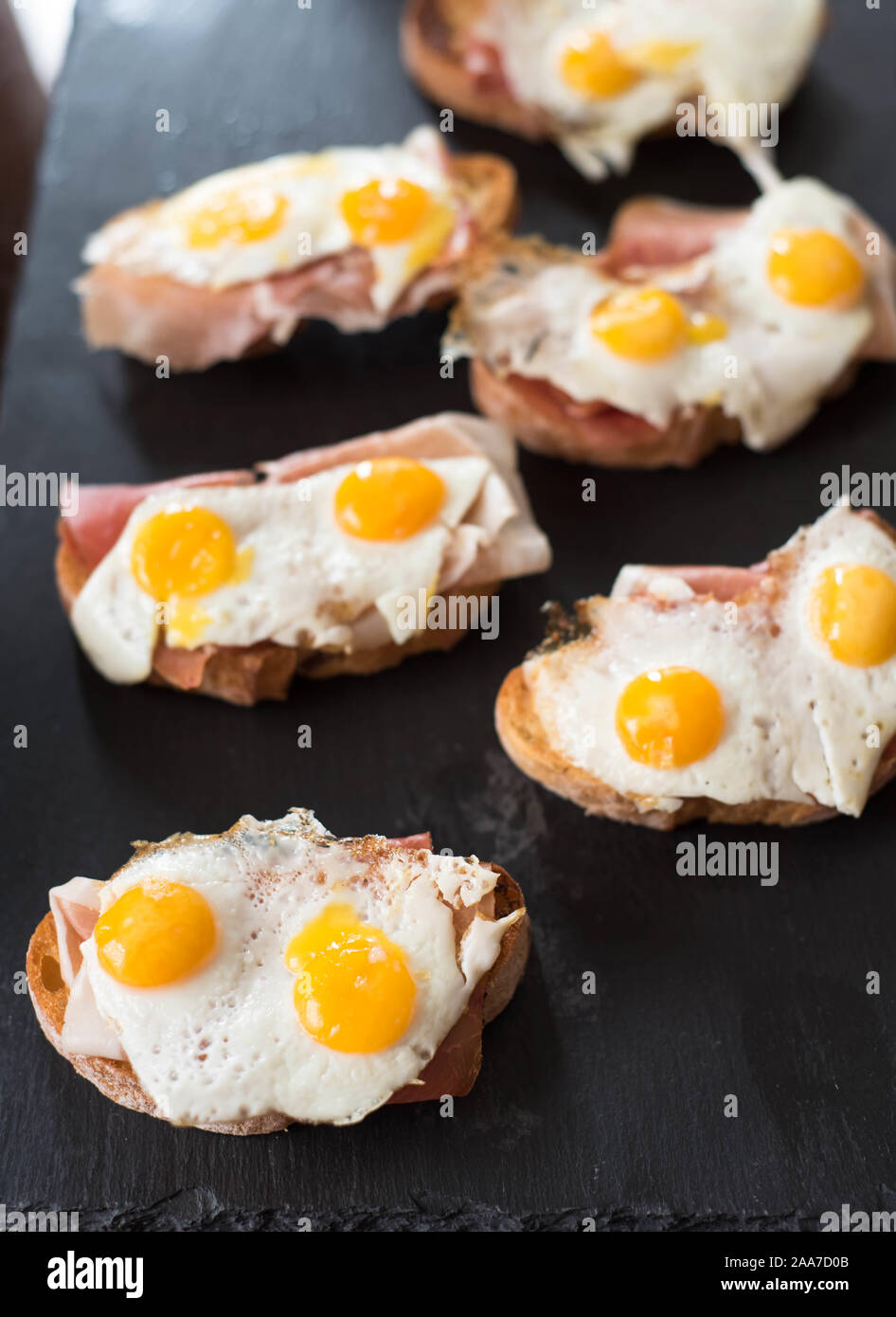 Bruschettas aux oeufs de caille frit et jamon Banque D'Images