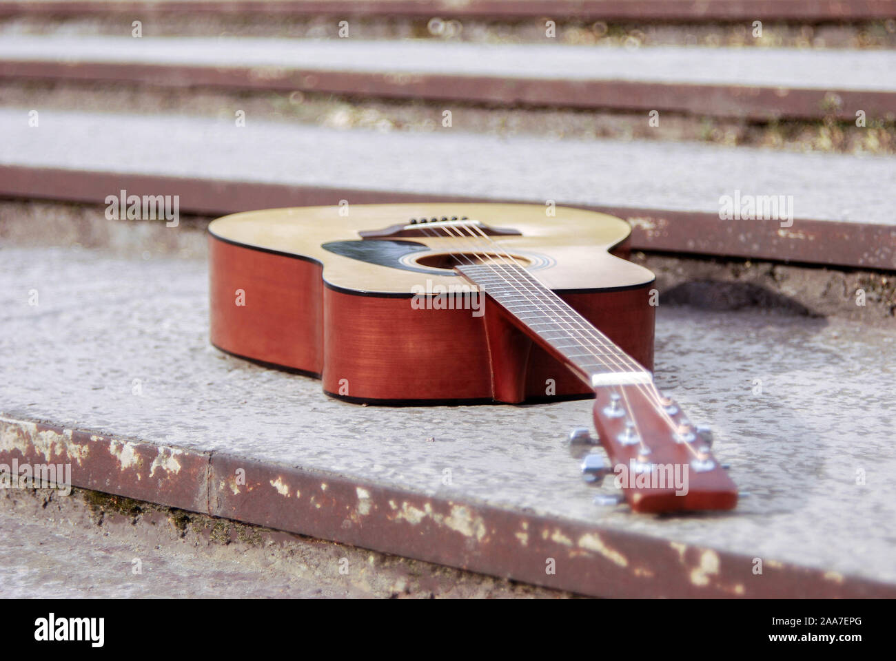 Guitare acoustique, instrument couché sur les étapes d'une ancienne dalle de béton chaîne acoustique guitare moderne, sur l'arrière-plan de la texture comme suit Banque D'Images