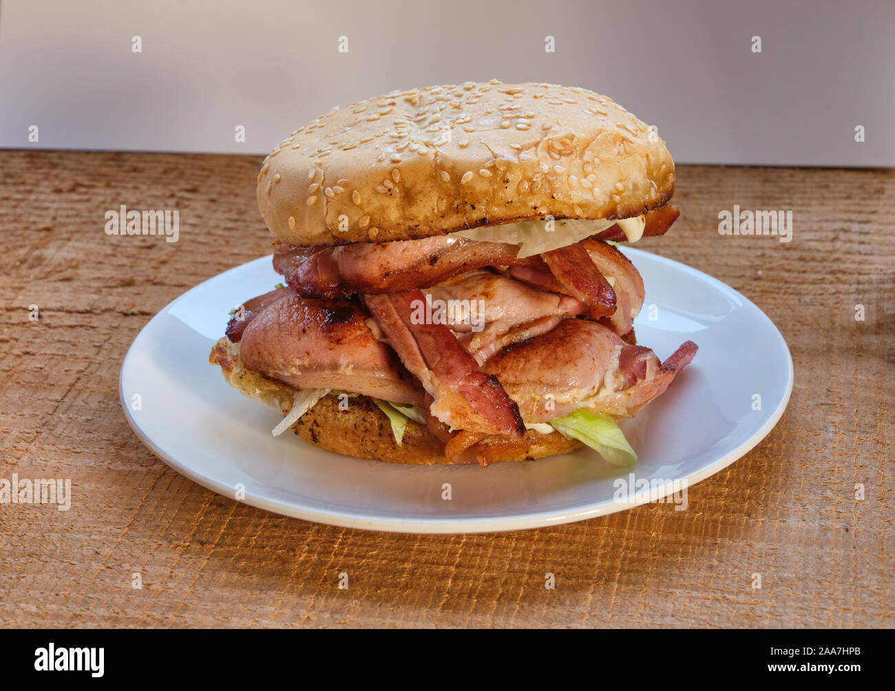 Bacon roll ou butty de laitue sur une assiette blanche et de bois dans un rouleau recouvert de sésame ou bap Banque D'Images