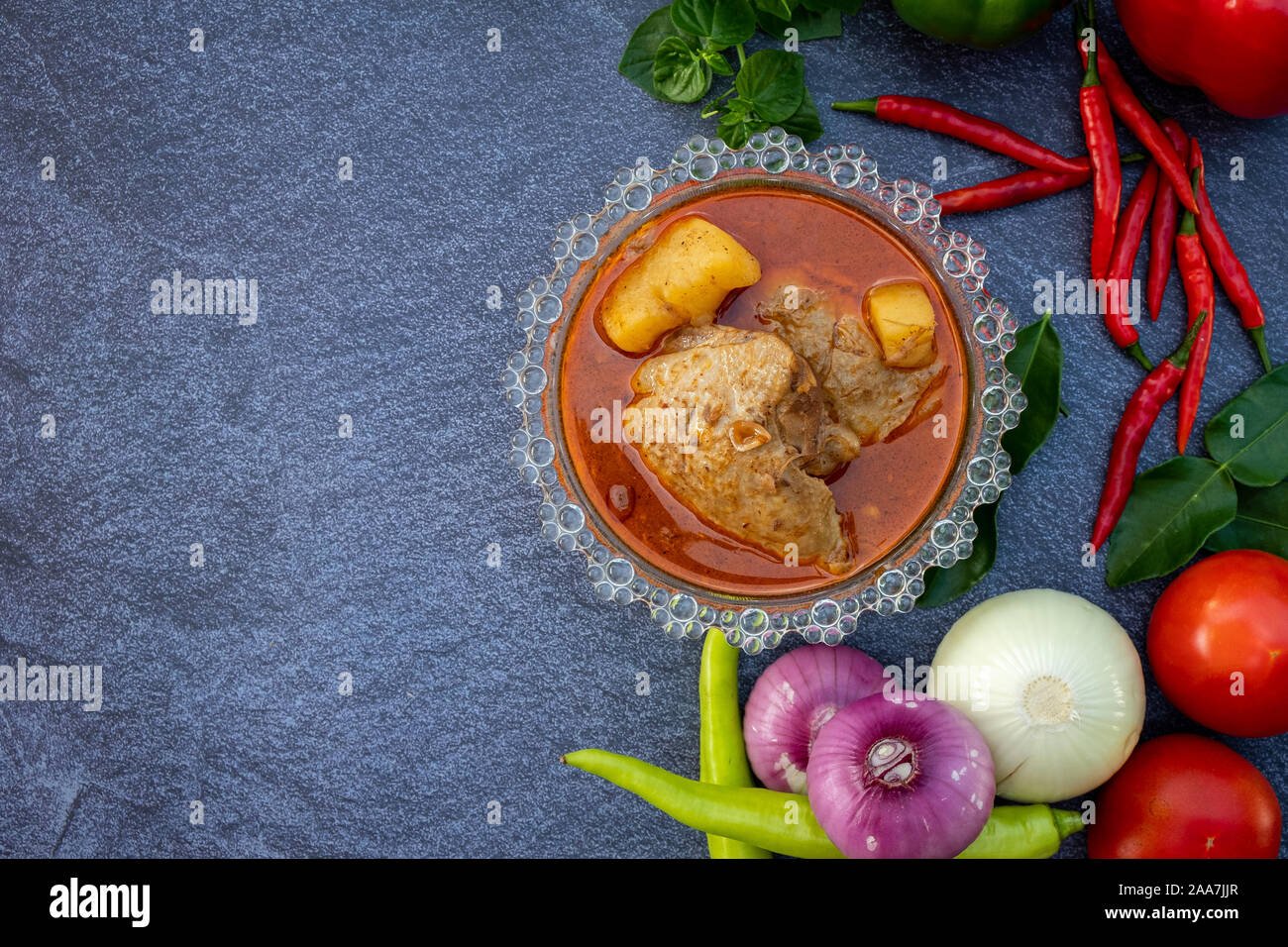 La nourriture asiatique, telles que Thai red curry Vue supérieure avec copie espace.Les légumes et les ingrédients sont autour de la bonne cuisine design sur l'arrière-plan en pierre. Banque D'Images