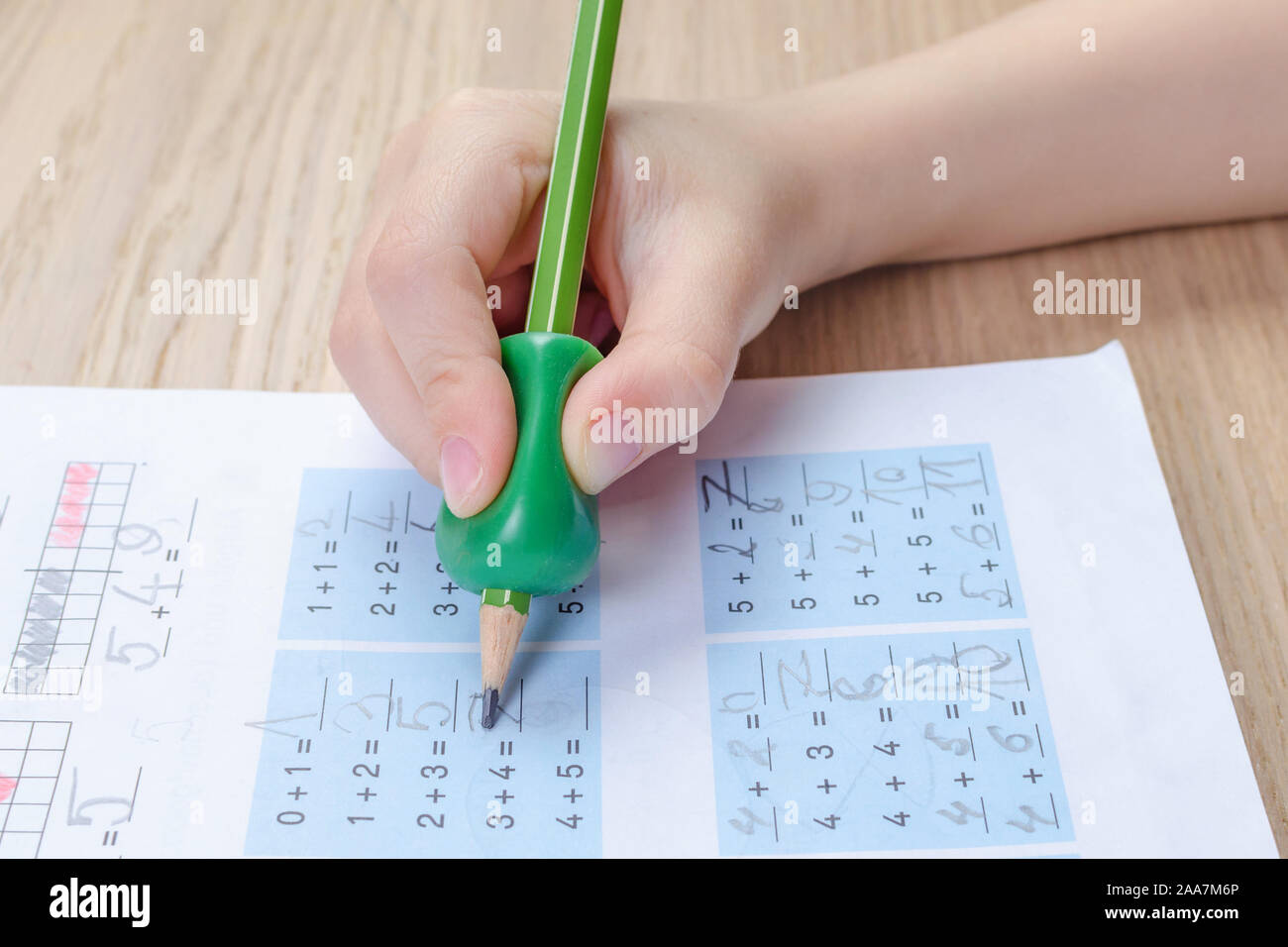 La main de l'enfant avec l'outil d'écriture de l'aide à la mauvaise tenue  du crayon, homewortk, mathématiques Photo Stock - Alamy