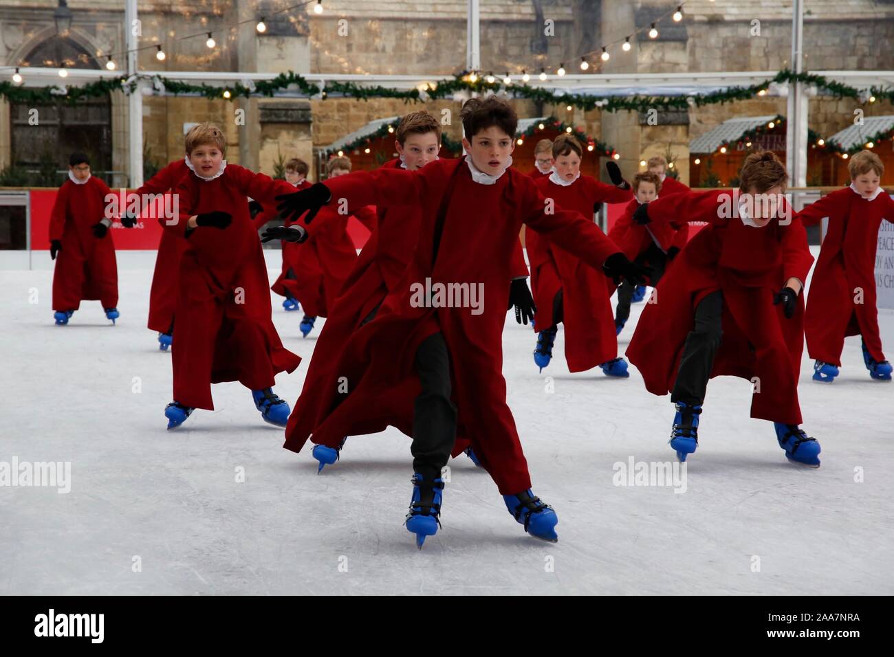 Winchester, Hampshire, Royaume-Uni. 20 novembre 2019. Les choristes le patinage sur la patinoire naturelle de leurs robes rouges emblématiques à la cathédrale de Winchester les fêtes de Noël avec la tradition festive des choristes skating autour de la patinoire d'avance sur son ouverture demain. Credit : Carolyn Jenkins/Alamy Live News Banque D'Images