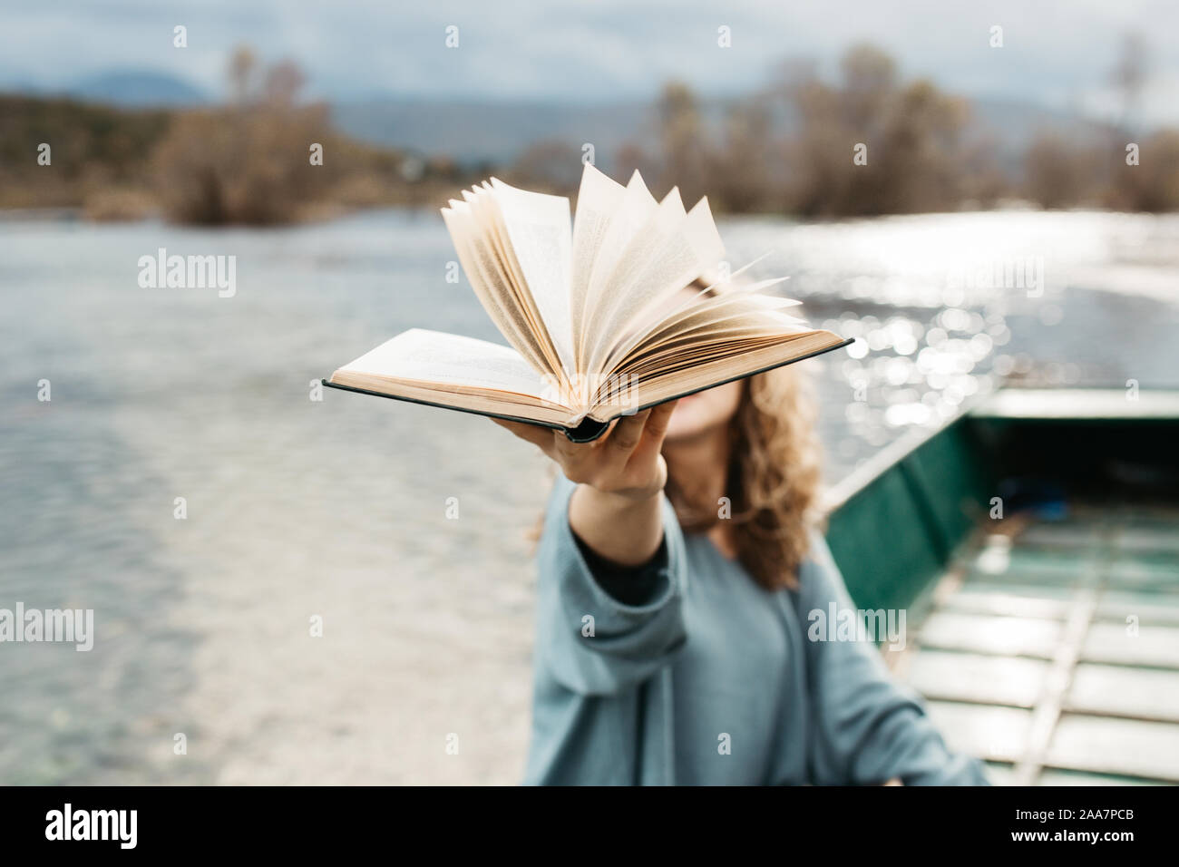 Portrait de la jeune belle femme assise sur un bateau et lecture d'un livre. Elle est bookworm et elle choisit entre quelques livres. Banque D'Images