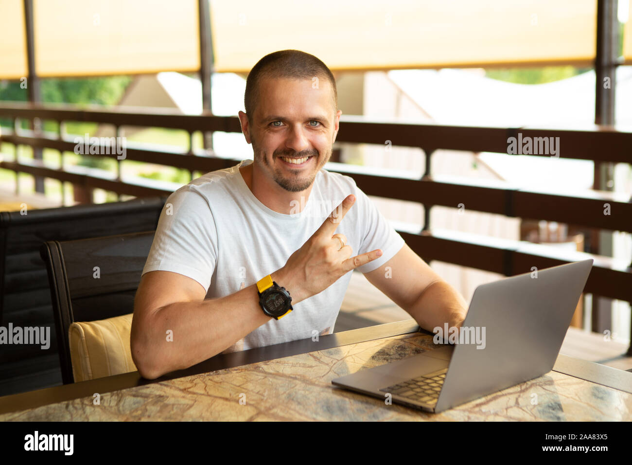 Geste Man Rock le sitting at desk with laptop Banque D'Images