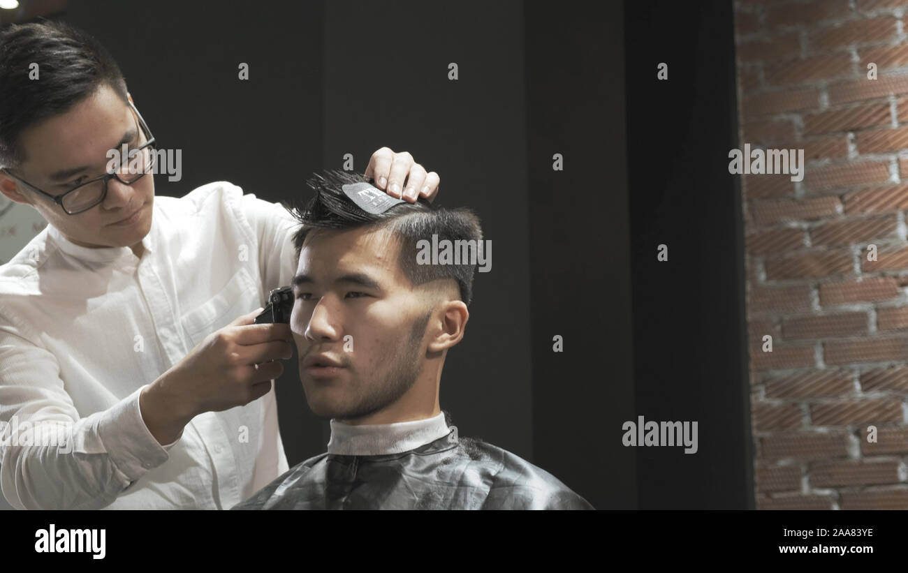 coupe de cheveux masculine dans un salon de coiffure en gros plan, client  se faisant couper les cheveux par un coiffeur avec un peigne et des ciseaux  11648227 Photo de stock chez Vecteezy