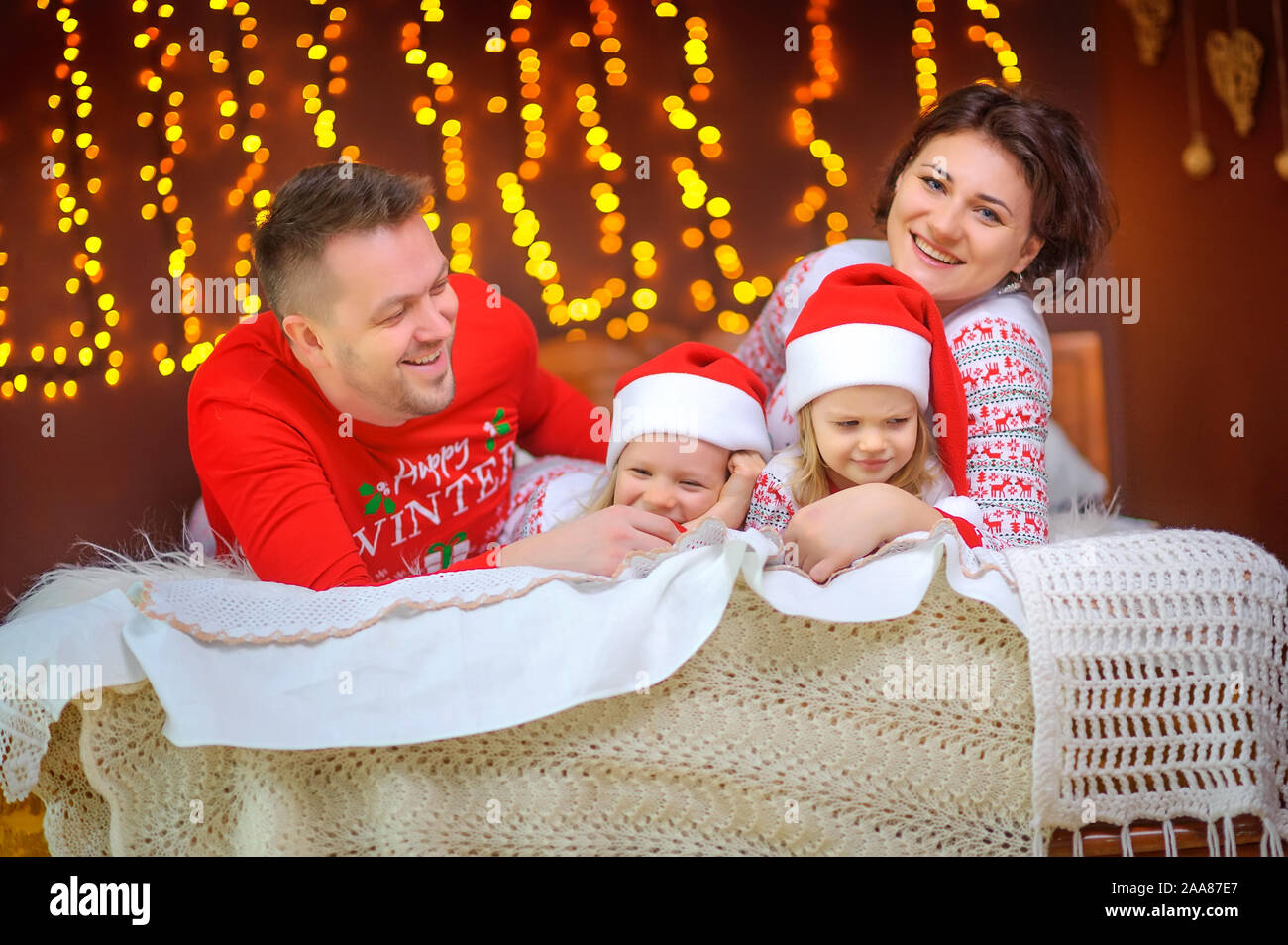 Portrait d'une famille heureuse. Assis en pyjama sur le lit et s'amuser. Le matin de Noël. Banque D'Images