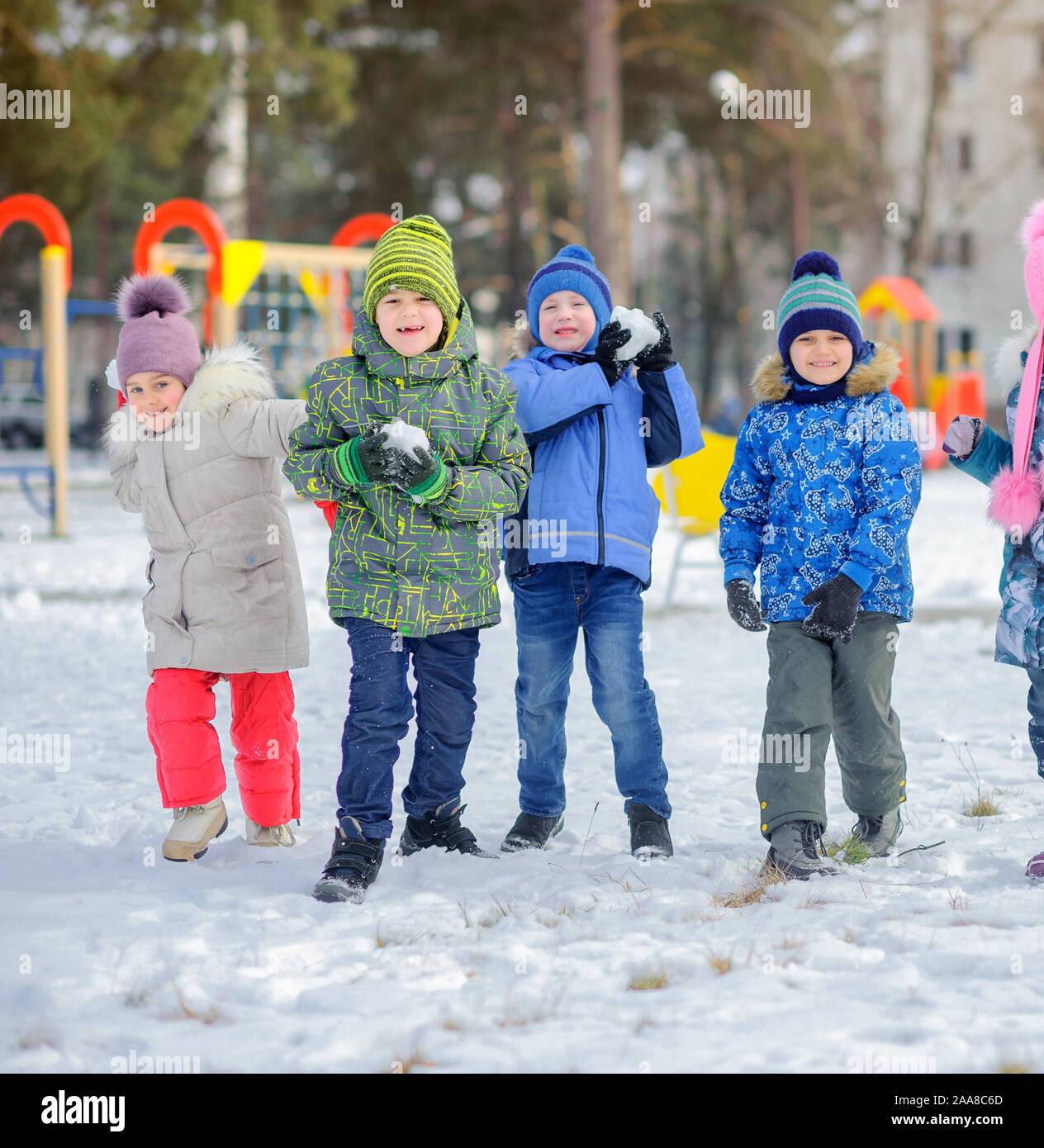 Un groupe d'enfants jouent et s'amuser sur une aire de jeux d'hiver. Jeter la neige et le rire. Vacances d'hiver. Banque D'Images