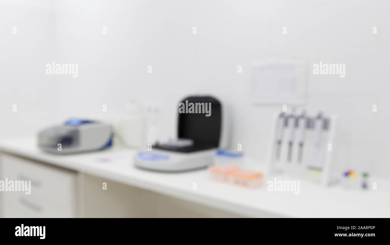 Photo floue de l'équipement de laboratoire médical sur la table à la lumière prix Banque D'Images
