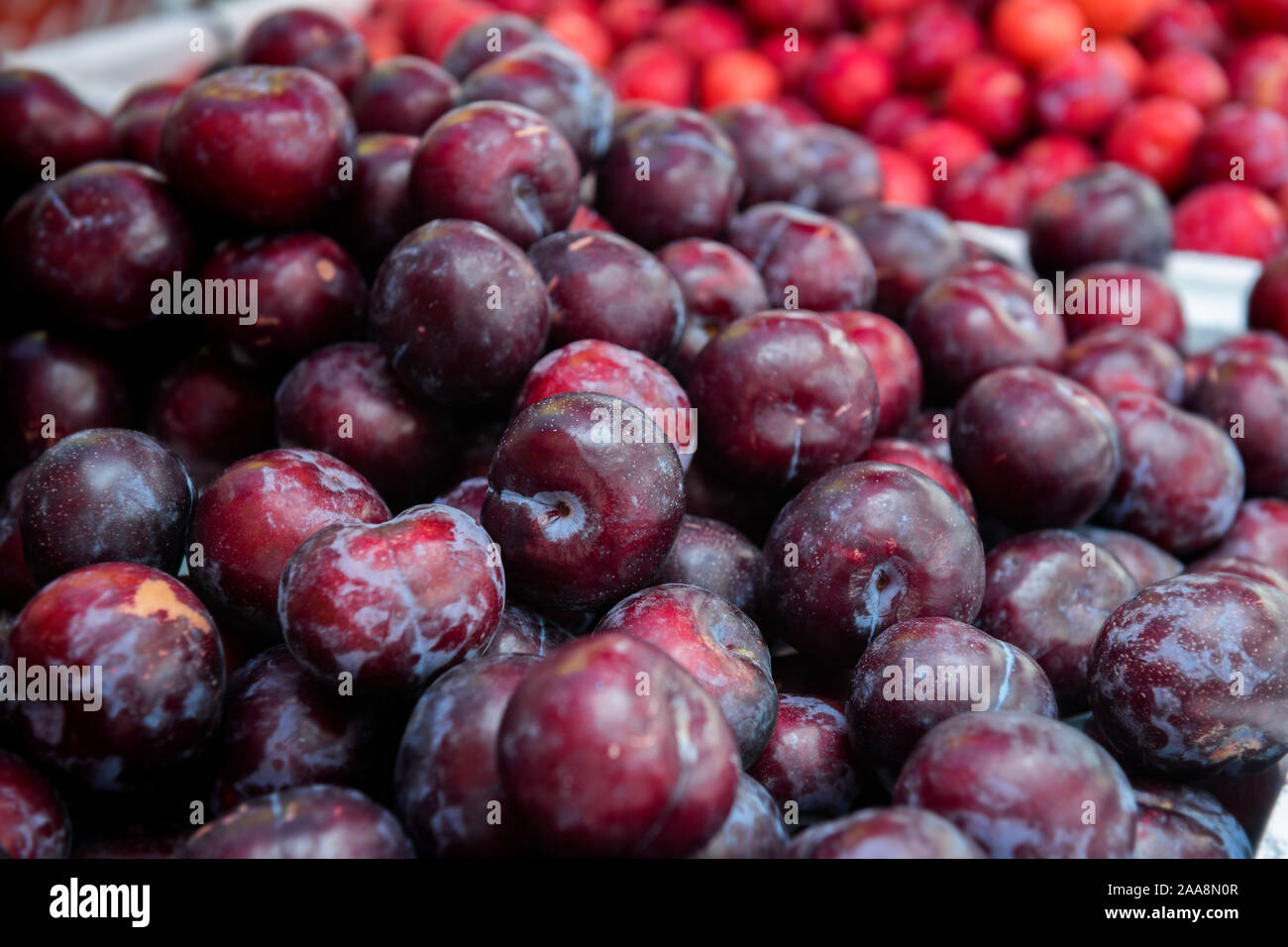 Groupe fruits prunes dans le marché en plein air avec un faible éclairage. Banque D'Images