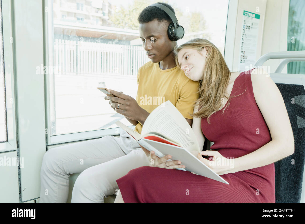 Fille et garçon lecture écouter de la musique sur le bus Banque D'Images