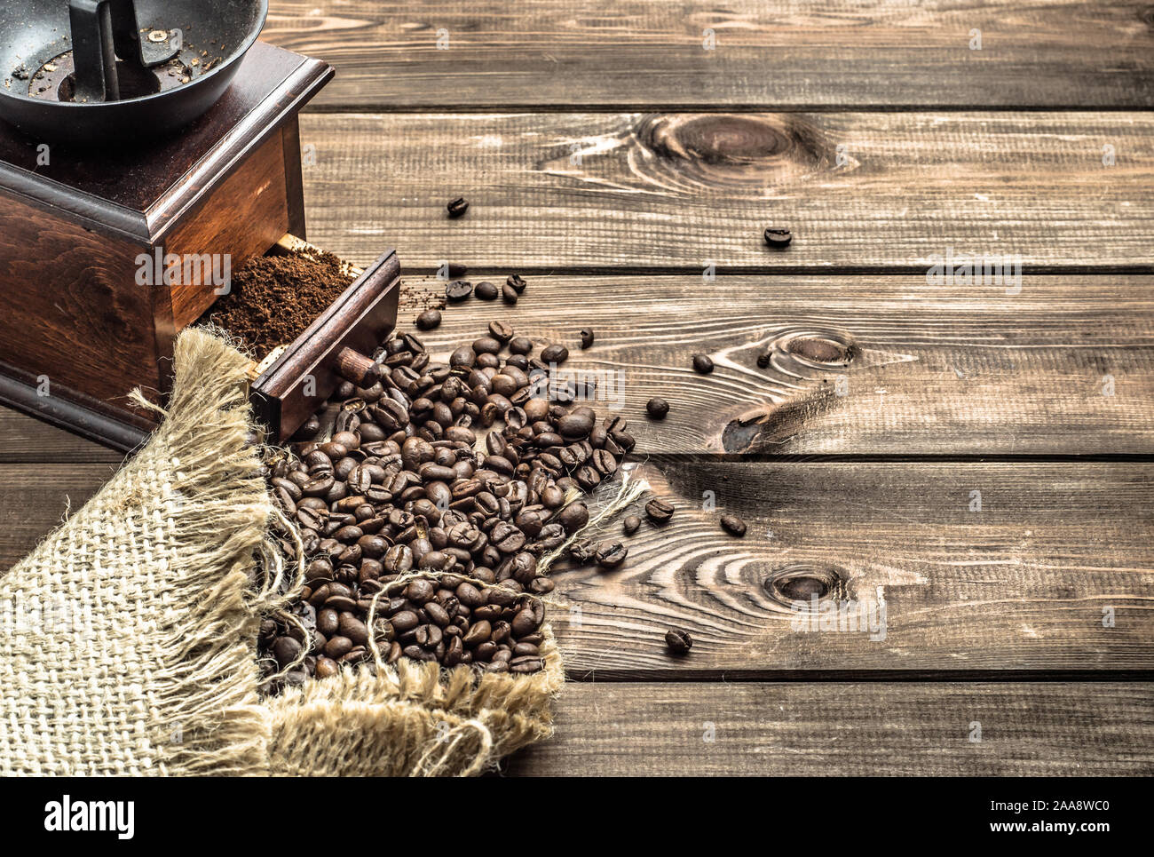 Moulin à café torréfié et de haricots en sac de jute sur fond rustique en bois Banque D'Images