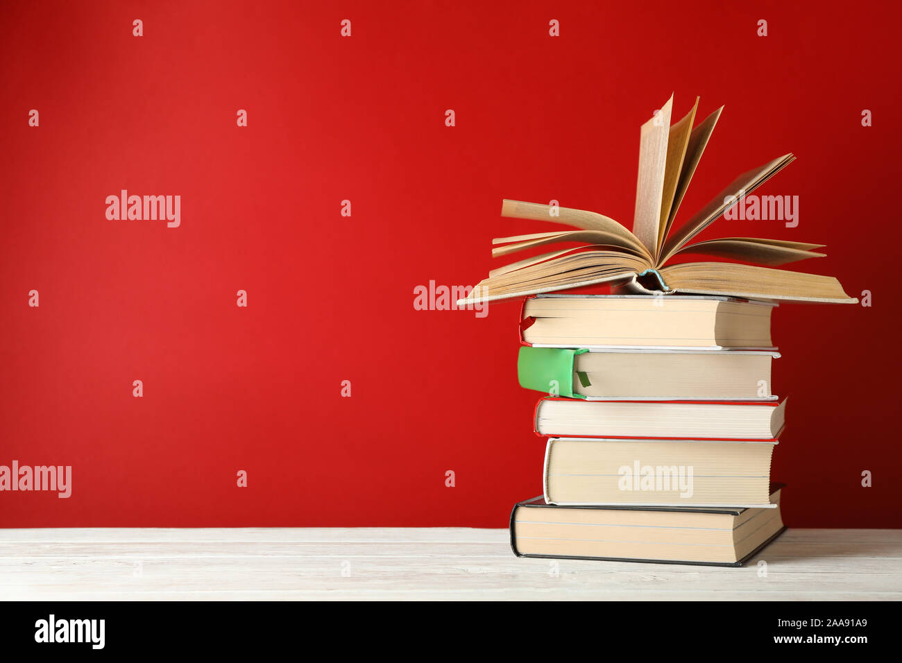 Pile de livres contre l'arrière-plan rouge, l'espace pour le texte Banque D'Images