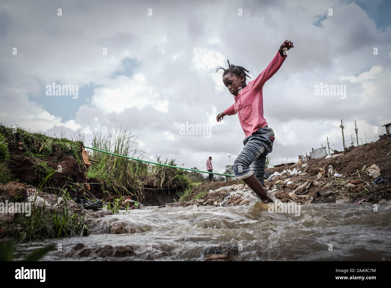 13 octobre 2019, Nairobi, Kenya : 9 ans maryann trouve son chemin à travers une rivière égout divisant par les bidonvilles de Kibera..que le monde vient à l'un de ses plus remarquables de jours. La plupart des enfants autour de différents endroits du monde sont vus en partageant leurs moments agréable et la solidarité. C'est un moment que pas beaucoup d'enfants autour de différentes parties du mot vivre à voir ou à déguster. Au Kenya aujourd'hui les enfants sont vus partager et apprécier leurs moments du monde libre et pacifique oublier les luttes quotidiennes dans la vie malgré les défis quotidiens. (Crédit Image : © Donwilson Odhiambo/SOPA Images via ZU Banque D'Images