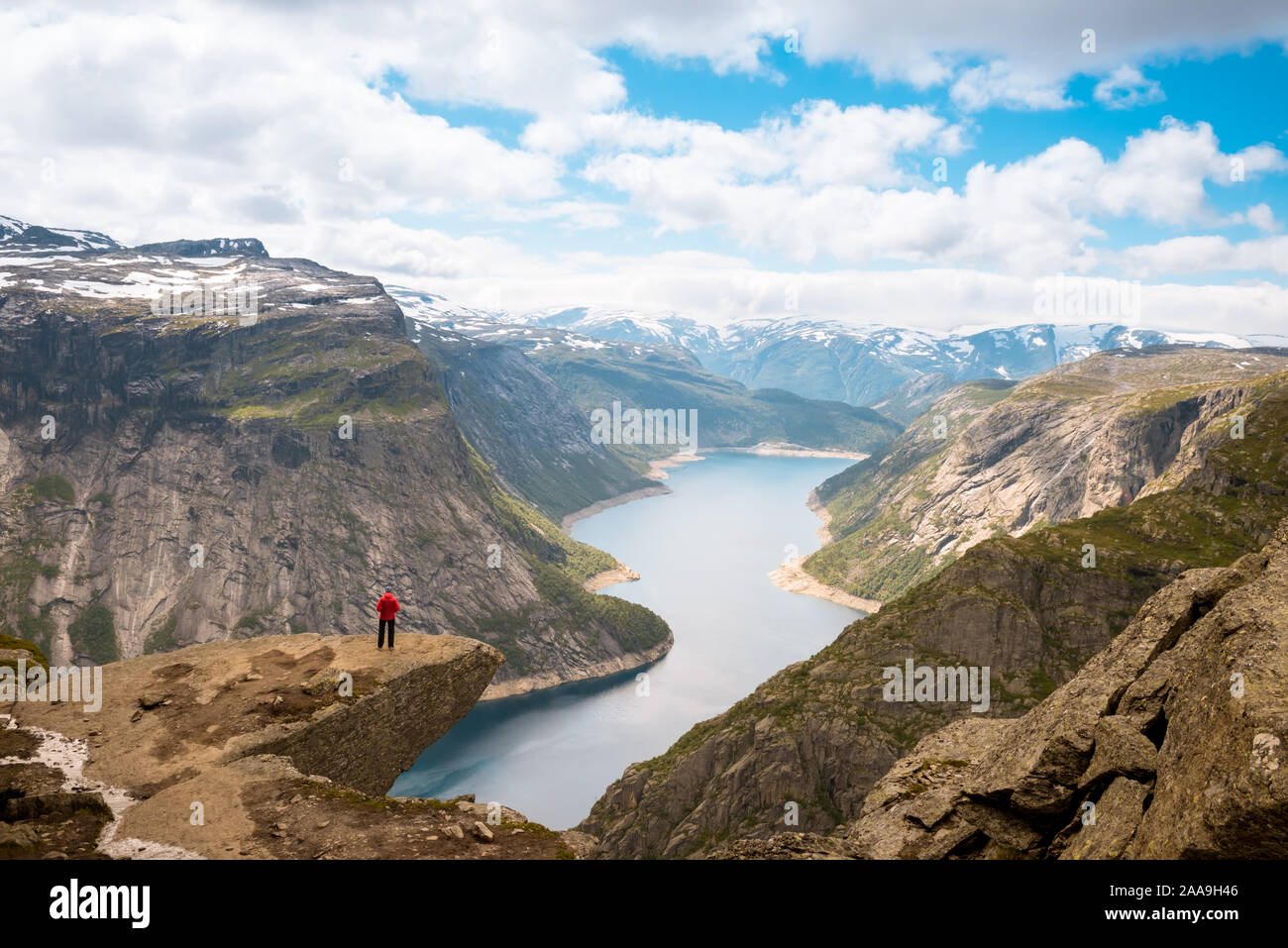 Sporty woman posing sur Trolltunga. Superbdevotie profiter du magnifique lac et de beau temps en Norvège. Banque D'Images