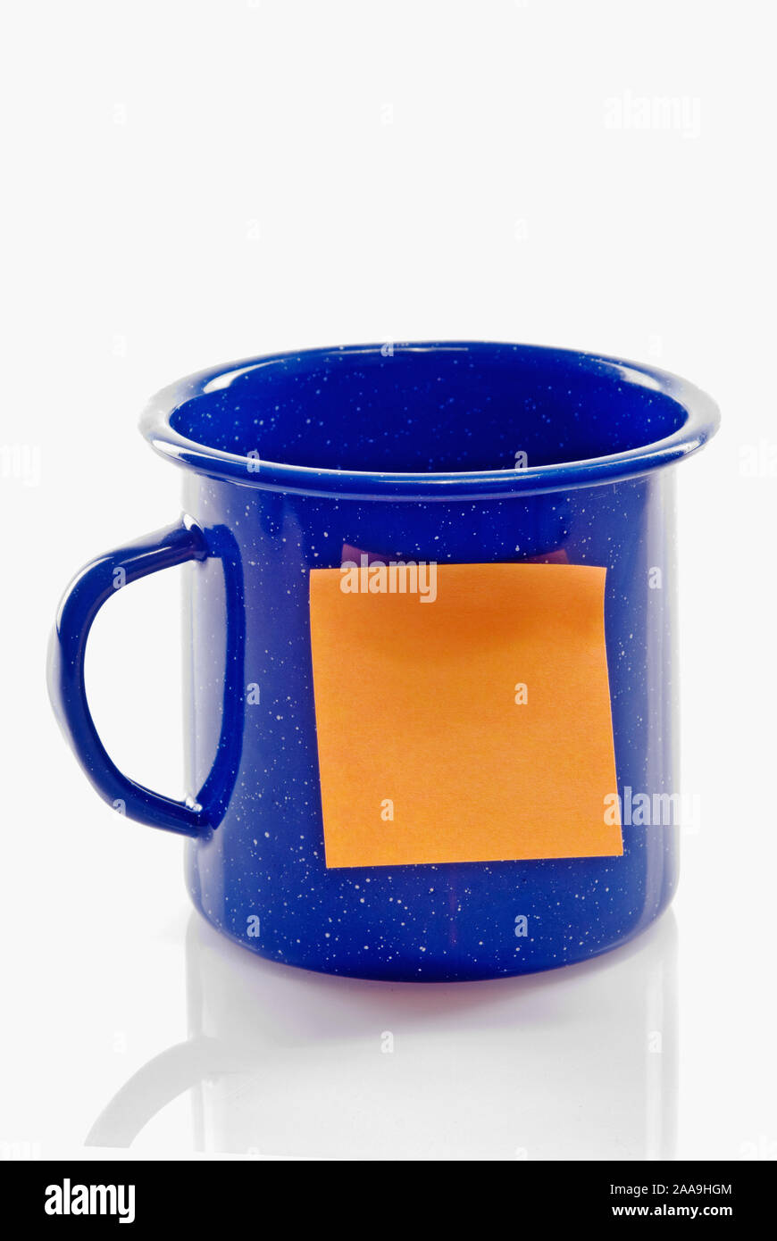 Nettoyer l'étain de couleur bleu vide la tasse de café camping avec un carré de couleur orange adhésif collant blanc note sur l'avant. Banque D'Images