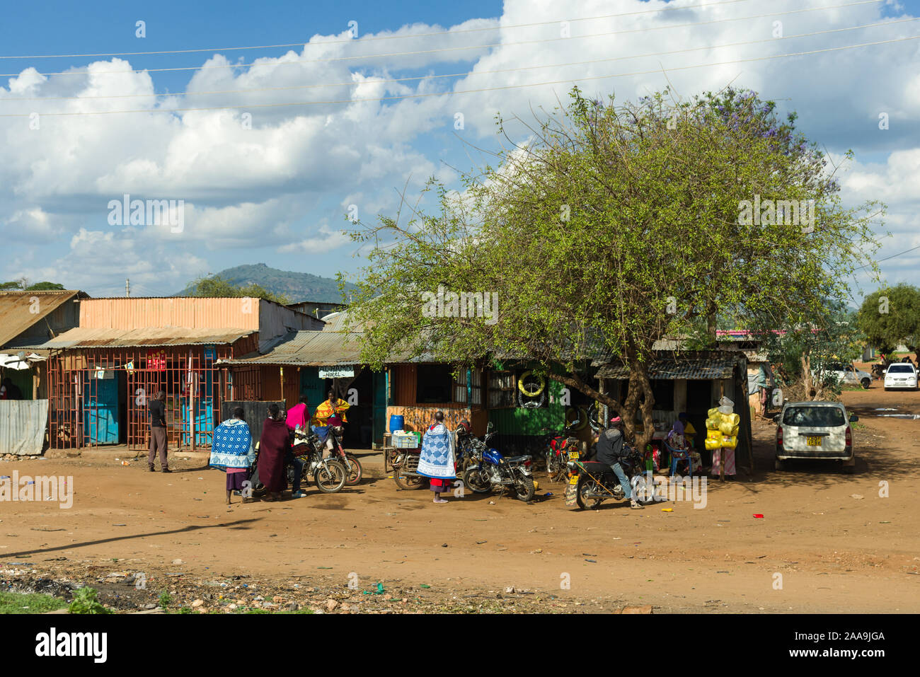 L'extérieur de petits magasins avec les habitants à l'extérieur dans une petite ville dans le comté de Kajiado, Kenya, Afrique de l'Est Banque D'Images