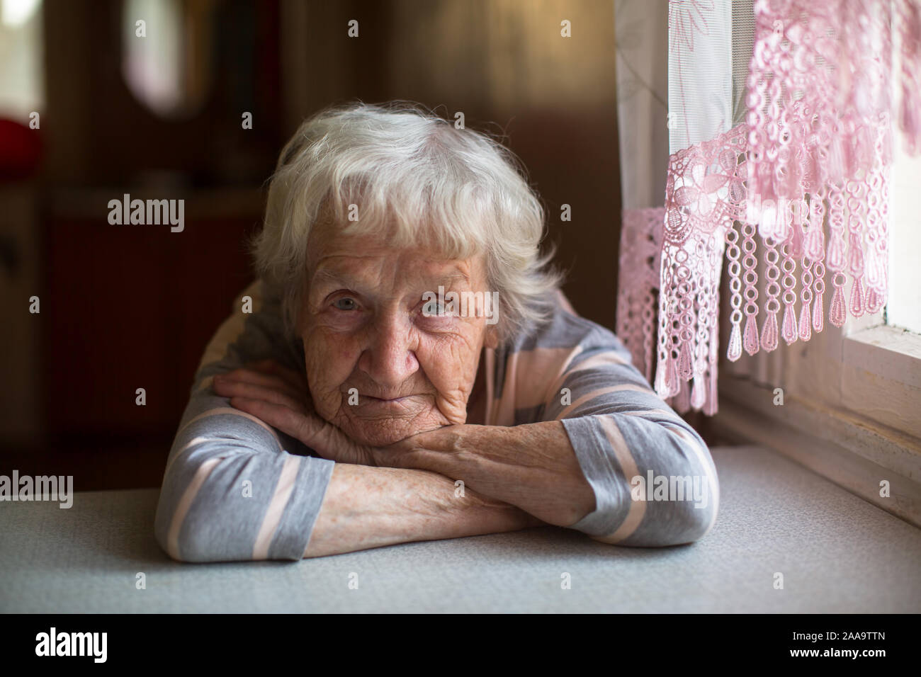 Close-up portrait d'une vieille femme à la table dans la maison. Banque D'Images