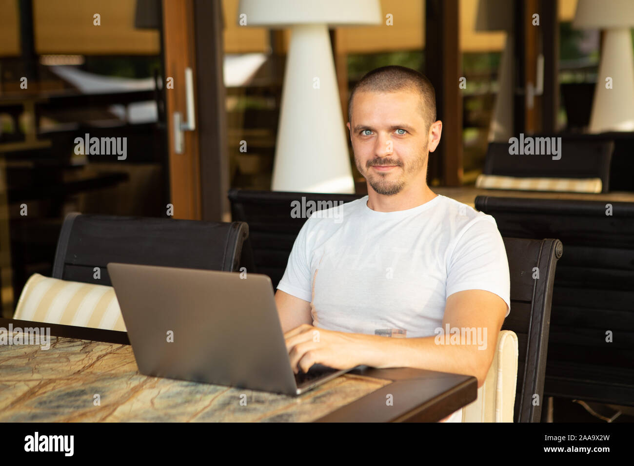 Homme avec portable à la caméra dans while sitting in cafe Banque D'Images