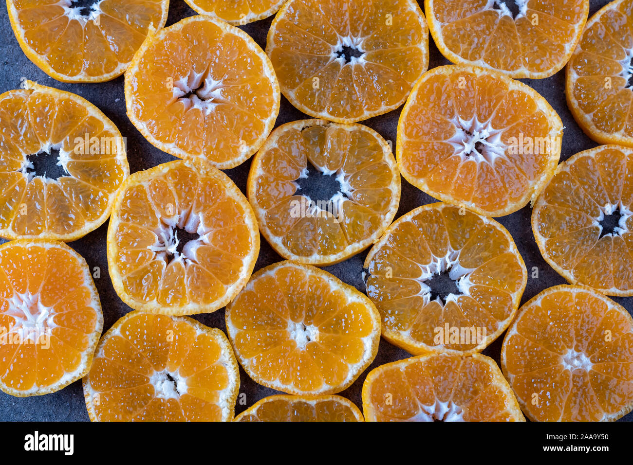 Morceaux ronds de la mandarine sur fond sombre. la texture de mandarine Banque D'Images