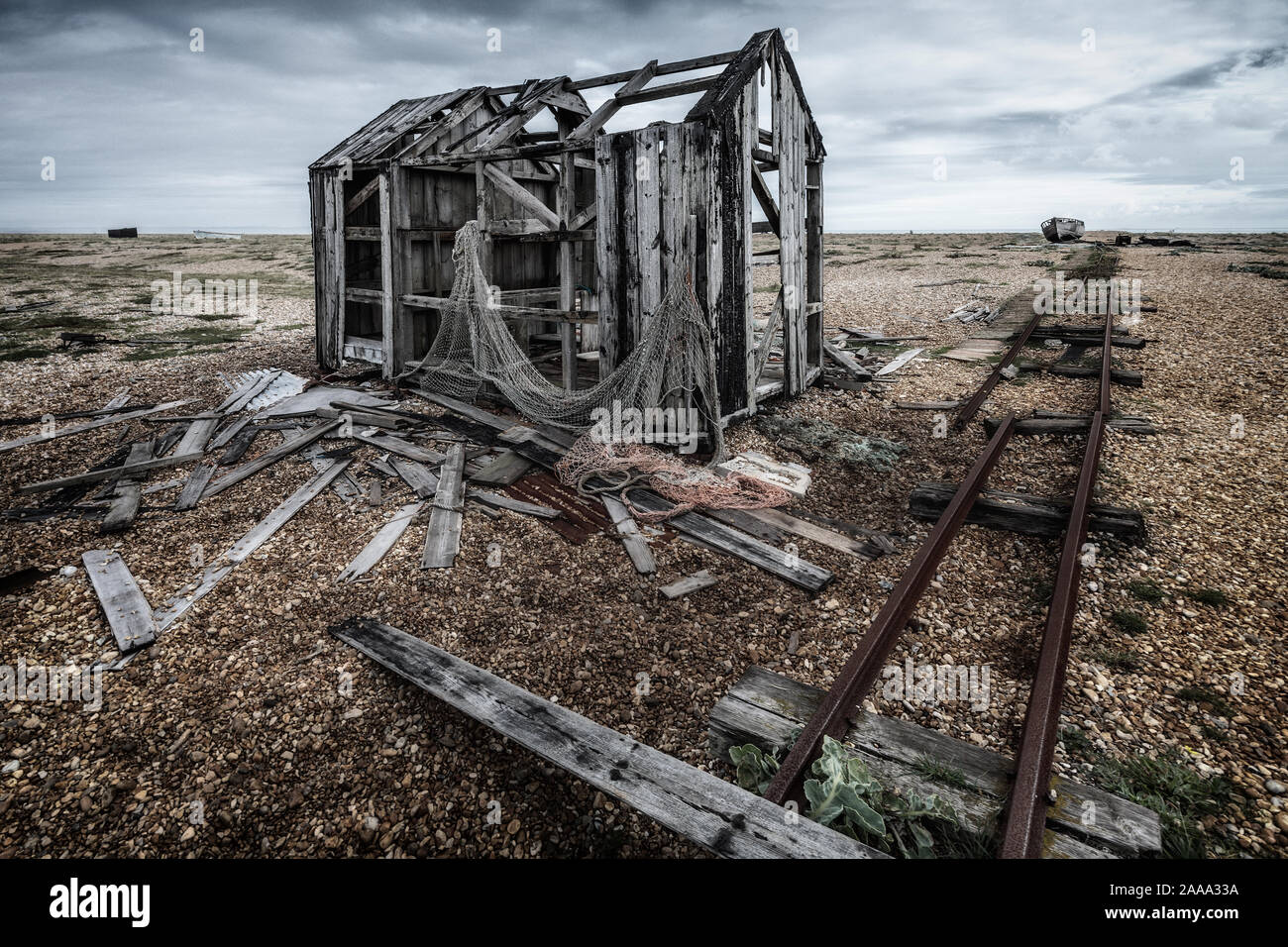 Cabane de pêche vieux abandonnés et rail track sur la plage de galets à Dungeness, Kent, England, UK Banque D'Images