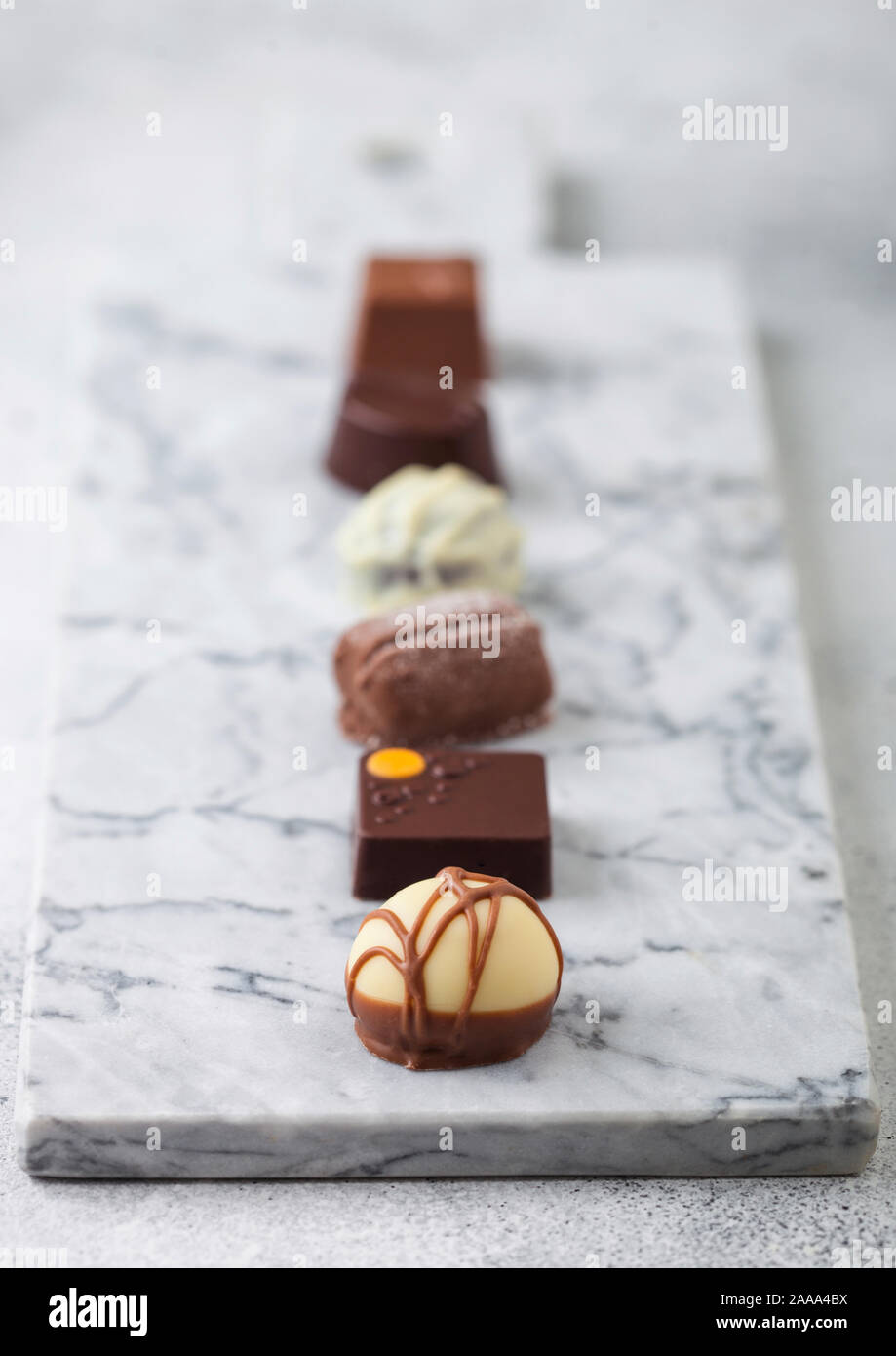 Sélection de chocolats de luxe sur la lumière marbel conseil. Blanc, noir et le chocolat au lait assortiment. Vue d'en haut Banque D'Images