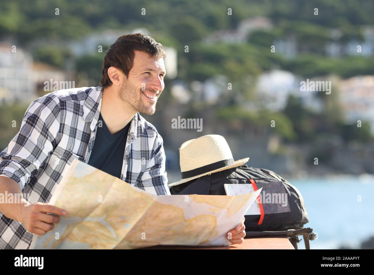 Heureux les touristes détenteurs d'une carte qui envisagent de vue d'un balcon donnant sur les vacances d'été sur la plage Banque D'Images