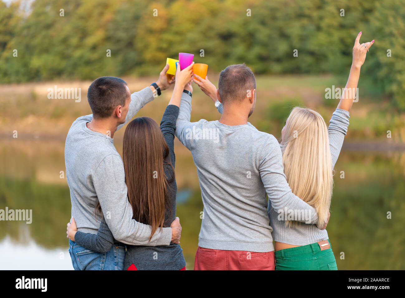 Pique-nique avec des amis au lac près de la tente de camping. Les amis de l'entreprise avoir pique-nique Randonnée nature background. Les randonneurs se détendre pendant le temps de boire. Summer picn Banque D'Images