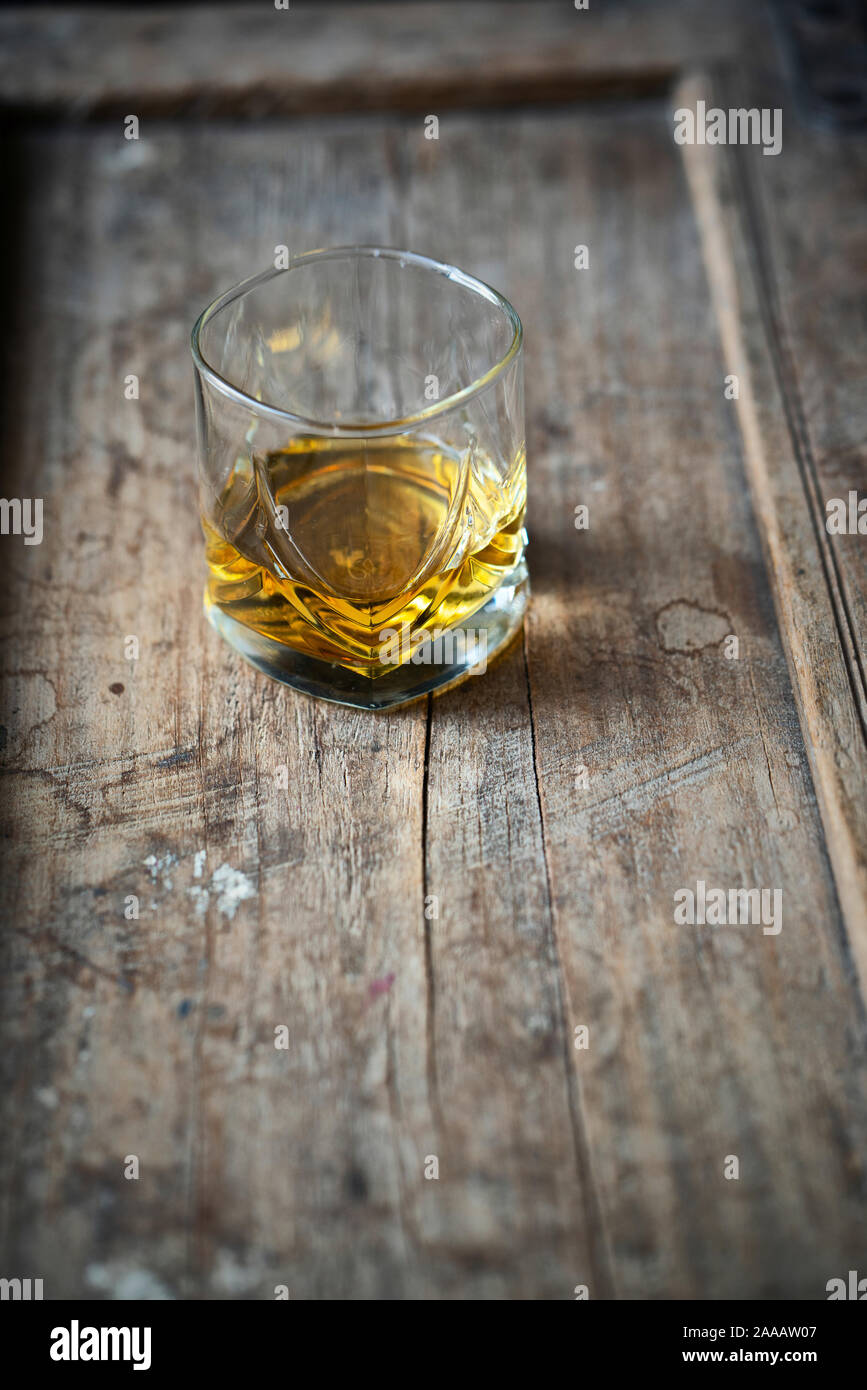 Avec verre de whisky single malt moirée d'or sur une vieille table en bois, utilisé minable d'en haut Banque D'Images