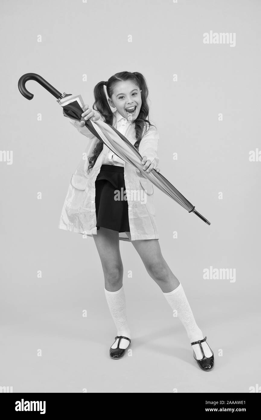 Au cas où il pleuvra. Heureux les petits écoliers en imperméable holding umbrella contre la pluie. Cute little girl avec accessoire de mode la maintient sec en temps de pluie humide. Pour sa grande douche de pluie Banque D'Images