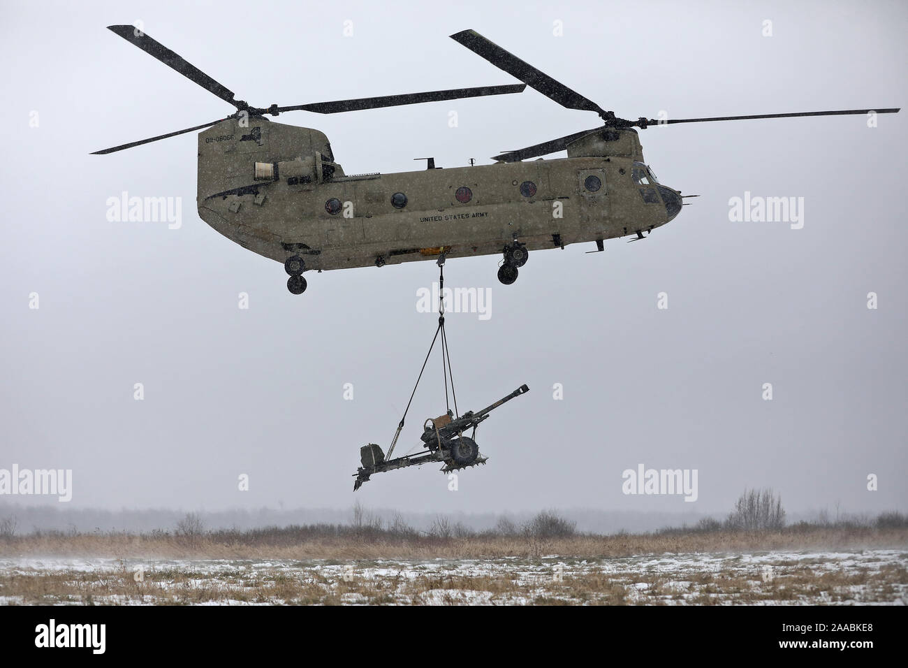 Un hélicoptère CH-47 Chinook décolle transportant un obusier M119A3 après que les soldats affectés au 2e Bataillon, 15e Régiment d'artillerie, 2e Brigade Combat Team, 10e division de montagne exécuté une opération air assault charge batterie de tir au cours de niveau de certification, le 19 novembre 2019, à Fort Drum, New York. (U.S. Photo de l'armée par le sergent. Paige Behringer) Banque D'Images