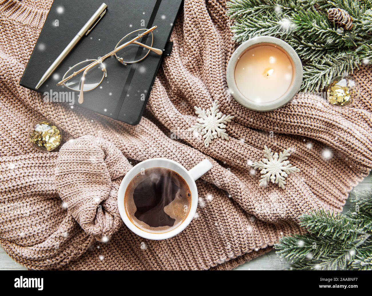 Mise à plat de la composition de Noël avec tasse de café, des bougies, des décorations et sapin sur un chandail tricoté Banque D'Images