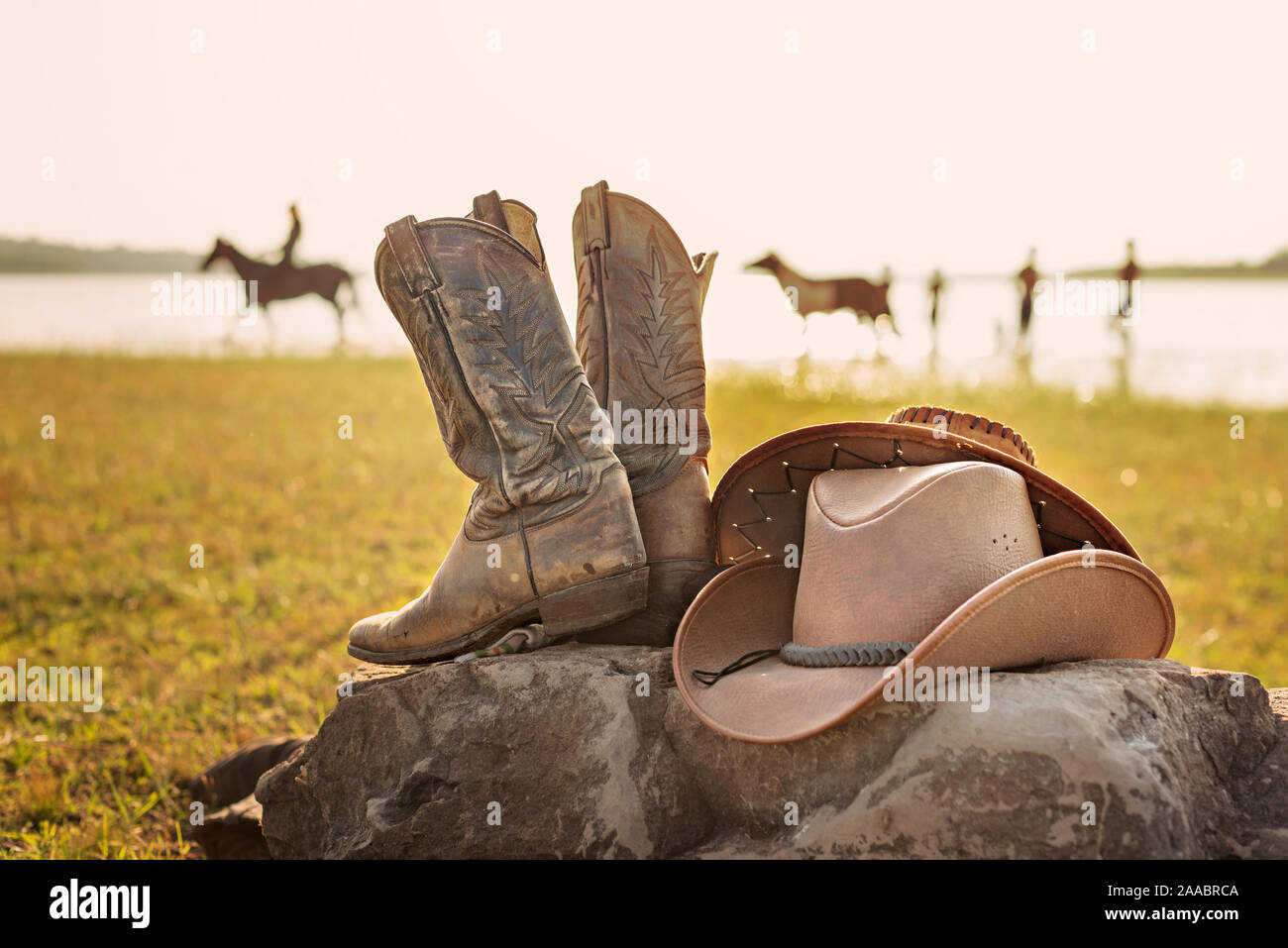 Wild West cowboy hat rétro et vieille paire de bottes en cuir sur le rocher Banque D'Images