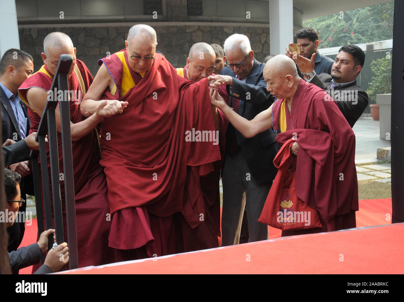 Le chef spirituel tibétain le dalaï-lama est aidé par le sida monter les marches lorsqu'il est arrivé à donner une conférence sur l'éthique universelle à New Delhi le jeudi N Banque D'Images