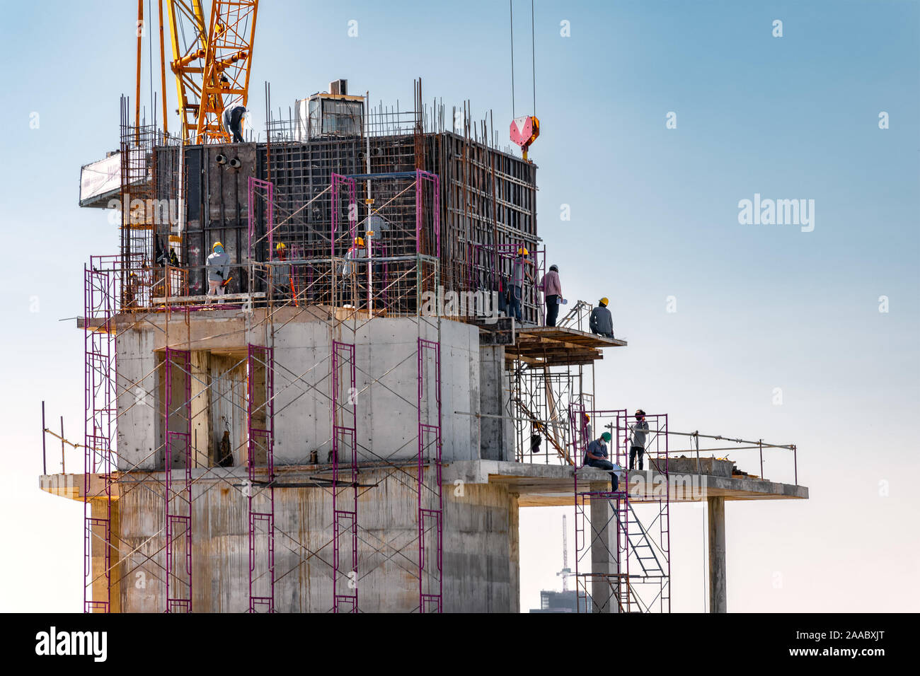 Vue aérienne de la construction d'un bâtiment avec une tour de Grue, échafaudage, coffrage, l'équipement, et les équipes de travail plaçant de barres d'armature en acier. Banque D'Images