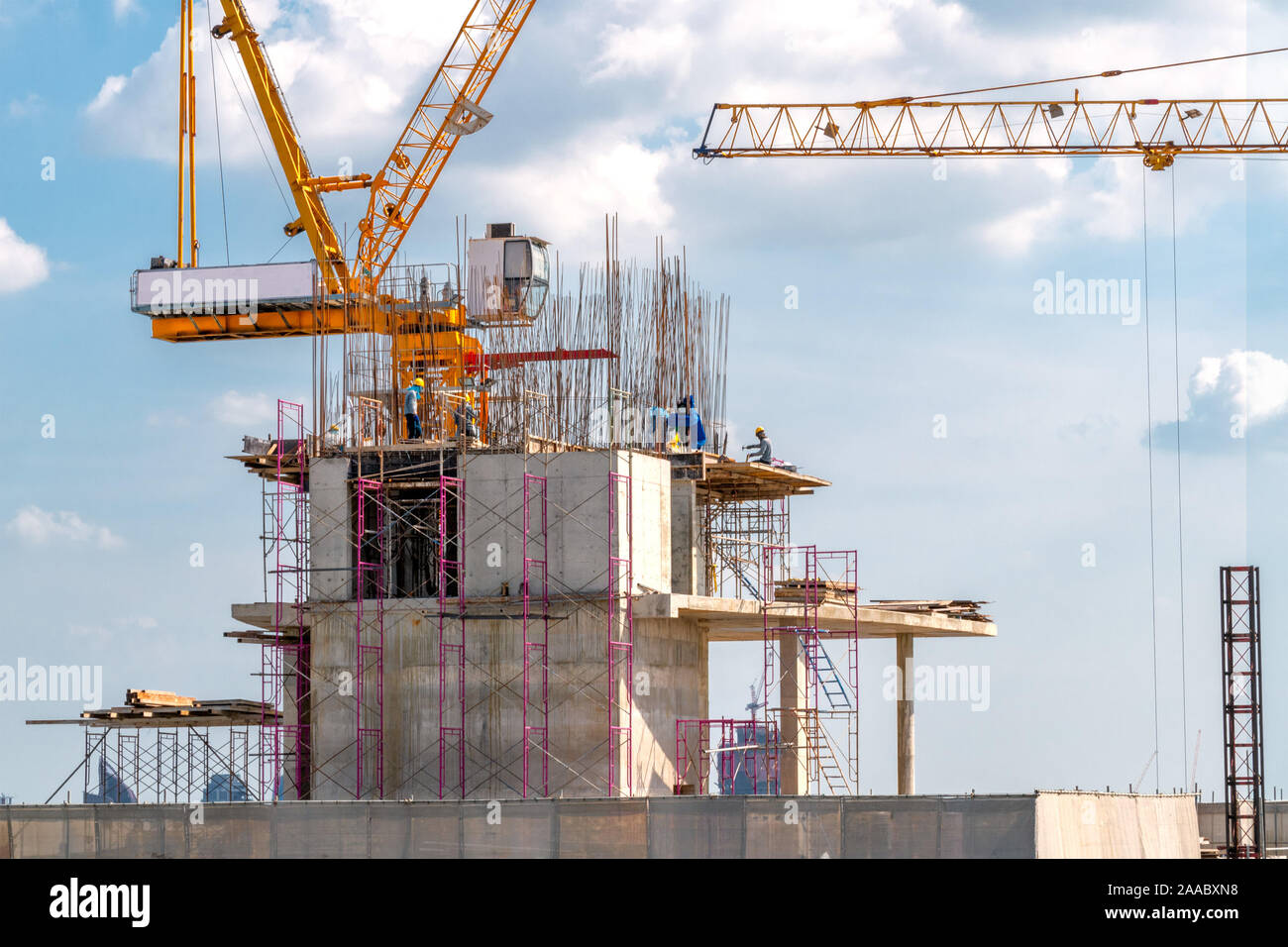 Vue aérienne de la construction d'un bâtiment avec une tour de Grue, échafaudage, coffrage, l'équipement, et les équipes de travail plaçant de barres d'armature en acier. Banque D'Images