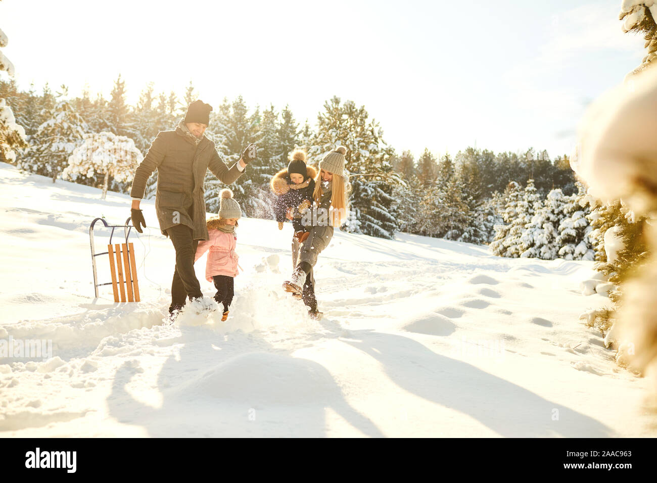 Playful couple avec enfants en hiver woods Banque D'Images