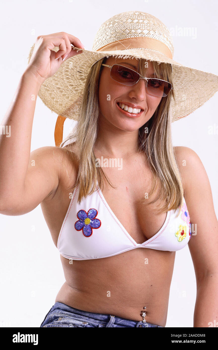 Junge Frau im Bikinioberteil und mit Sonnenbrille Strohhut | Jeune femme portant un bikini top, un chapeau et des lunettes de soleil Banque D'Images