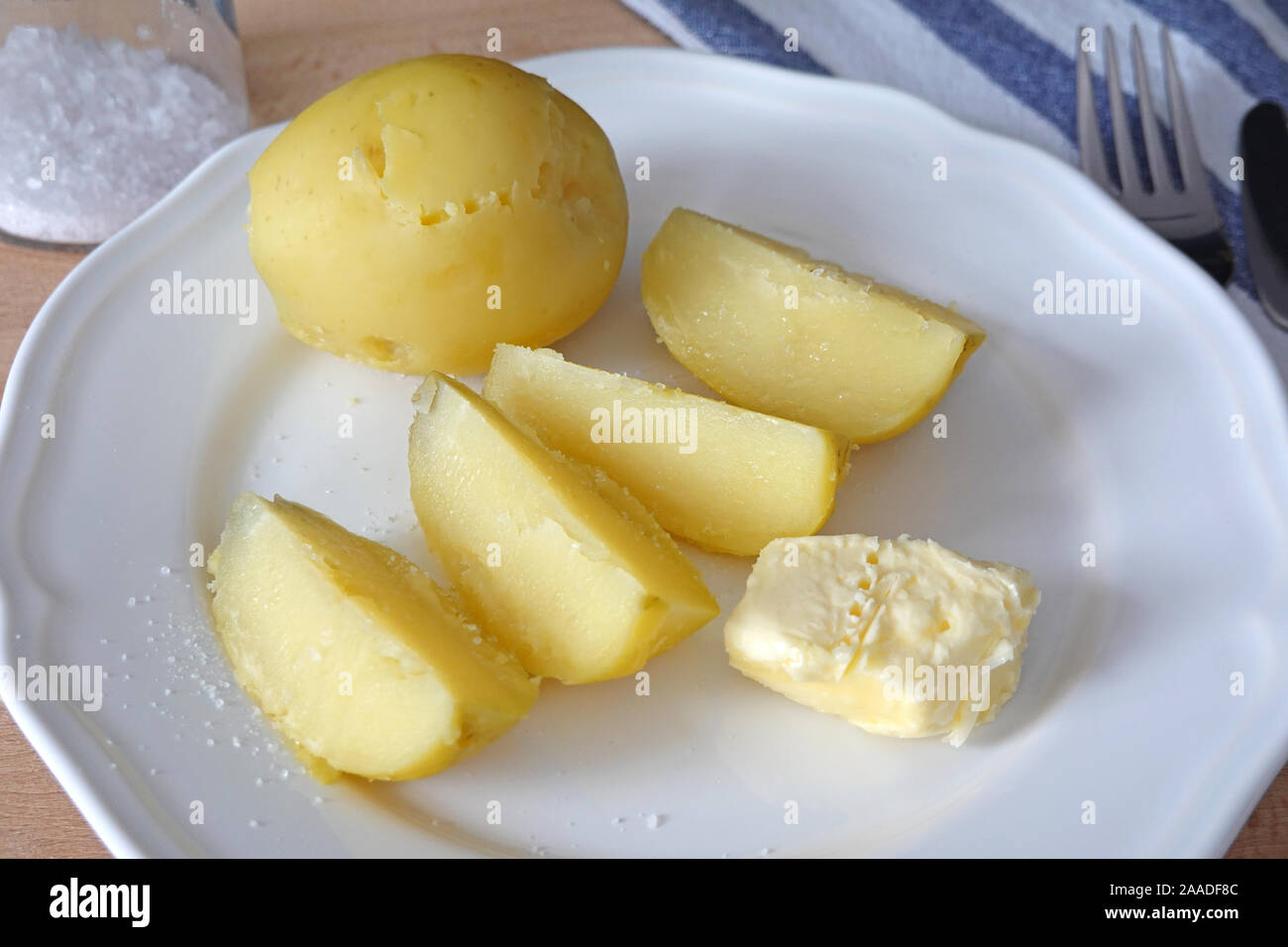 Les pommes de terre cuites avec du beurre et du sel que le dîner ou déjeuner sur plaque blanche. Cose-up Banque D'Images