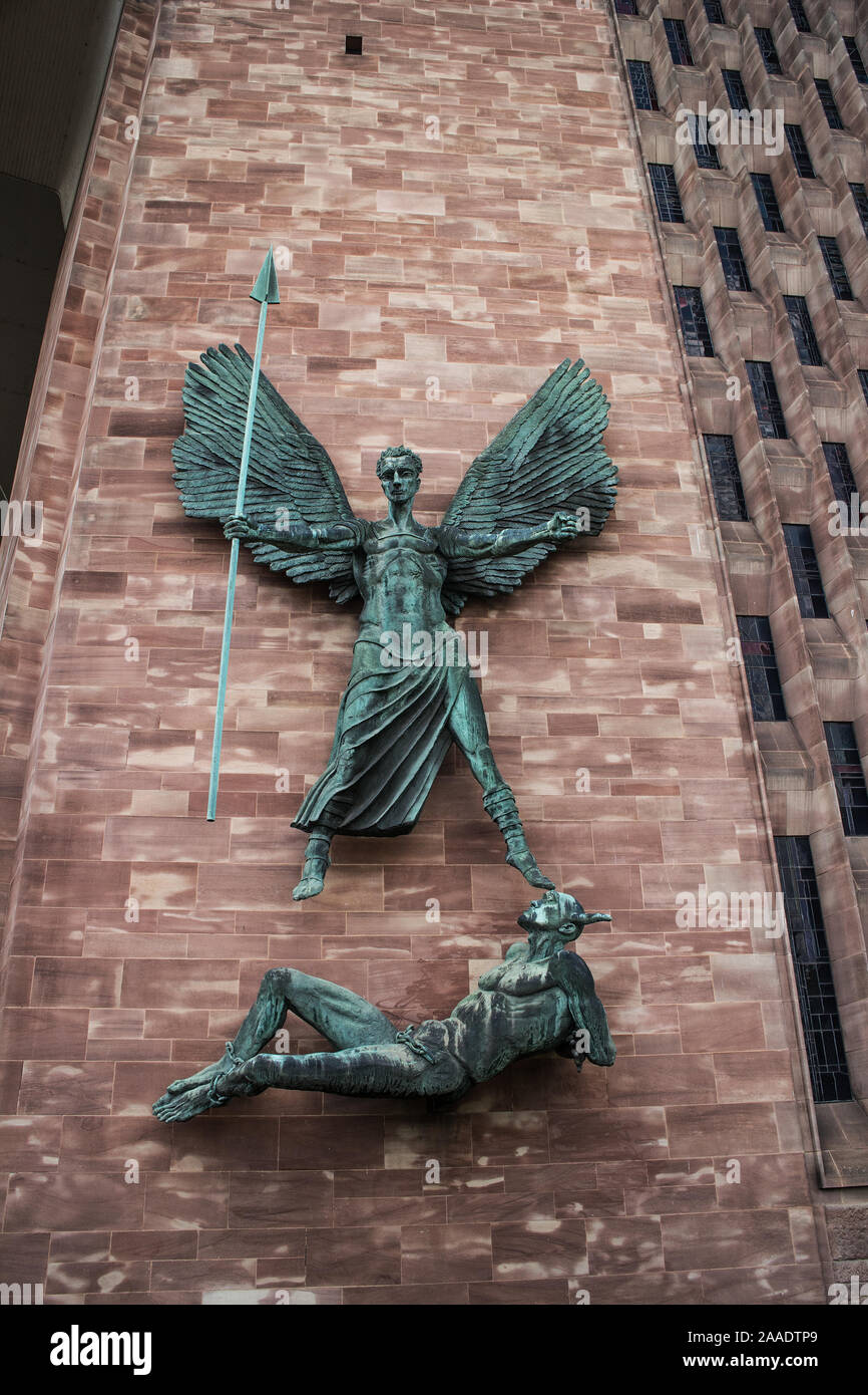 Sculptures en bronze de Saint Michel et le diable par Jacob Epstein sur le mur près de l'entrée de la cathédrale de Coventry Banque D'Images