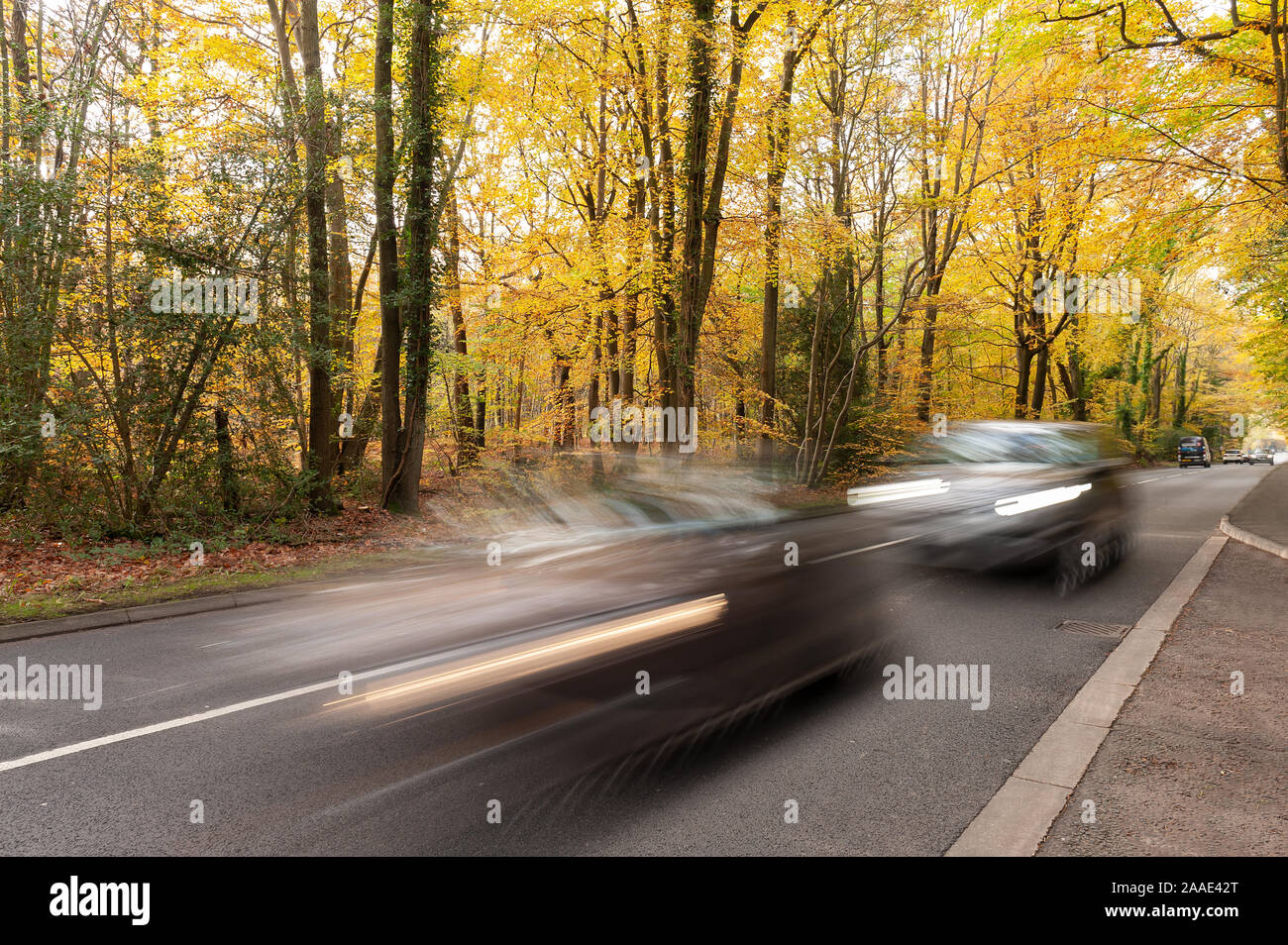 Queue à la vitesse de synchronisation sur A25 au cours de l'automne deux voitures très proches mauvaise conduite et signe de la rage, manque de considération pour la sécurité, la lumière terne Banque D'Images