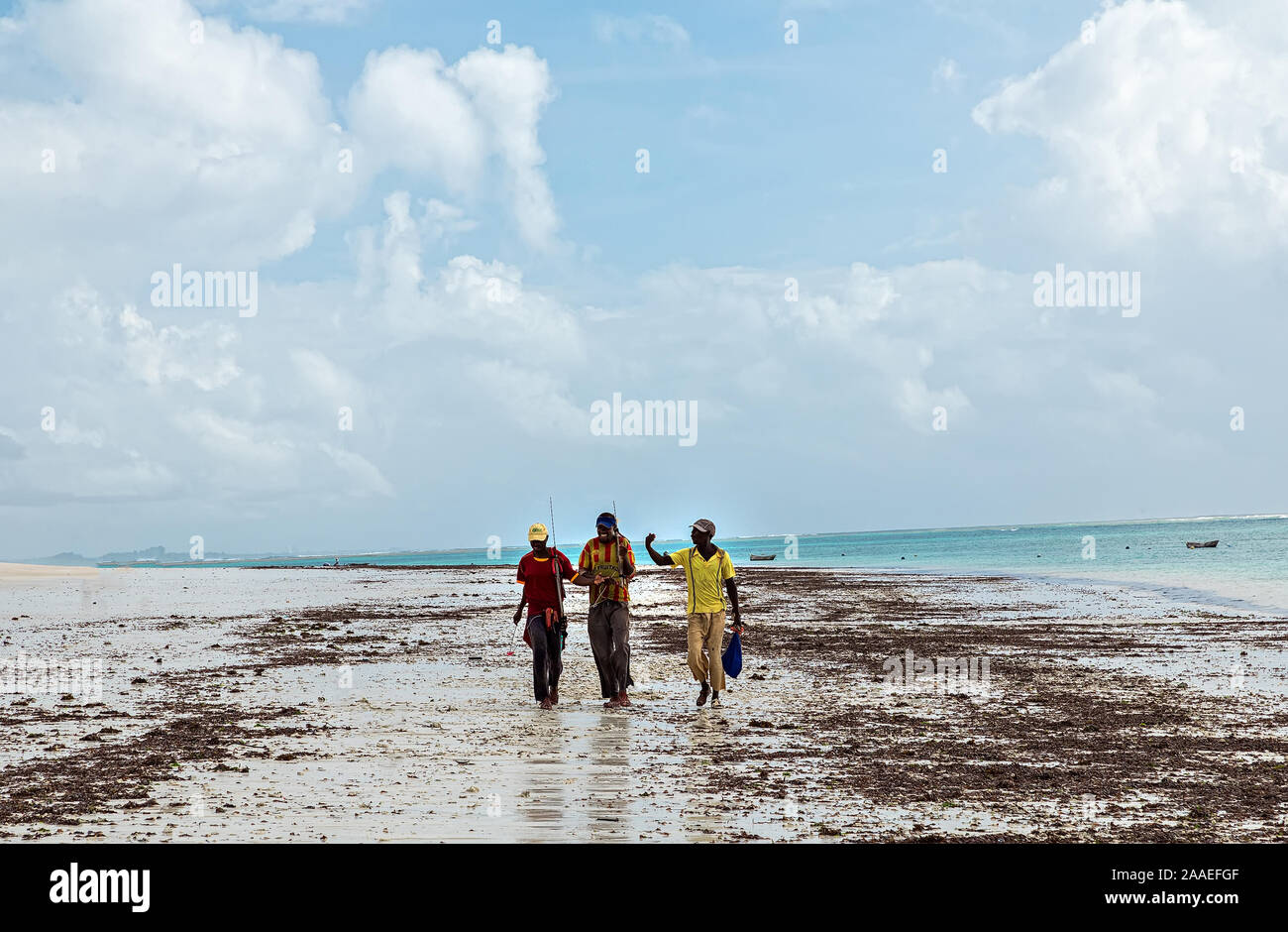 Diani, Mombasa, Kenya, Afrika oktober 13, 2019 trois pêcheurs africains avec des cannes à pêche à pied le long de l'océan et parlent entre eux Banque D'Images